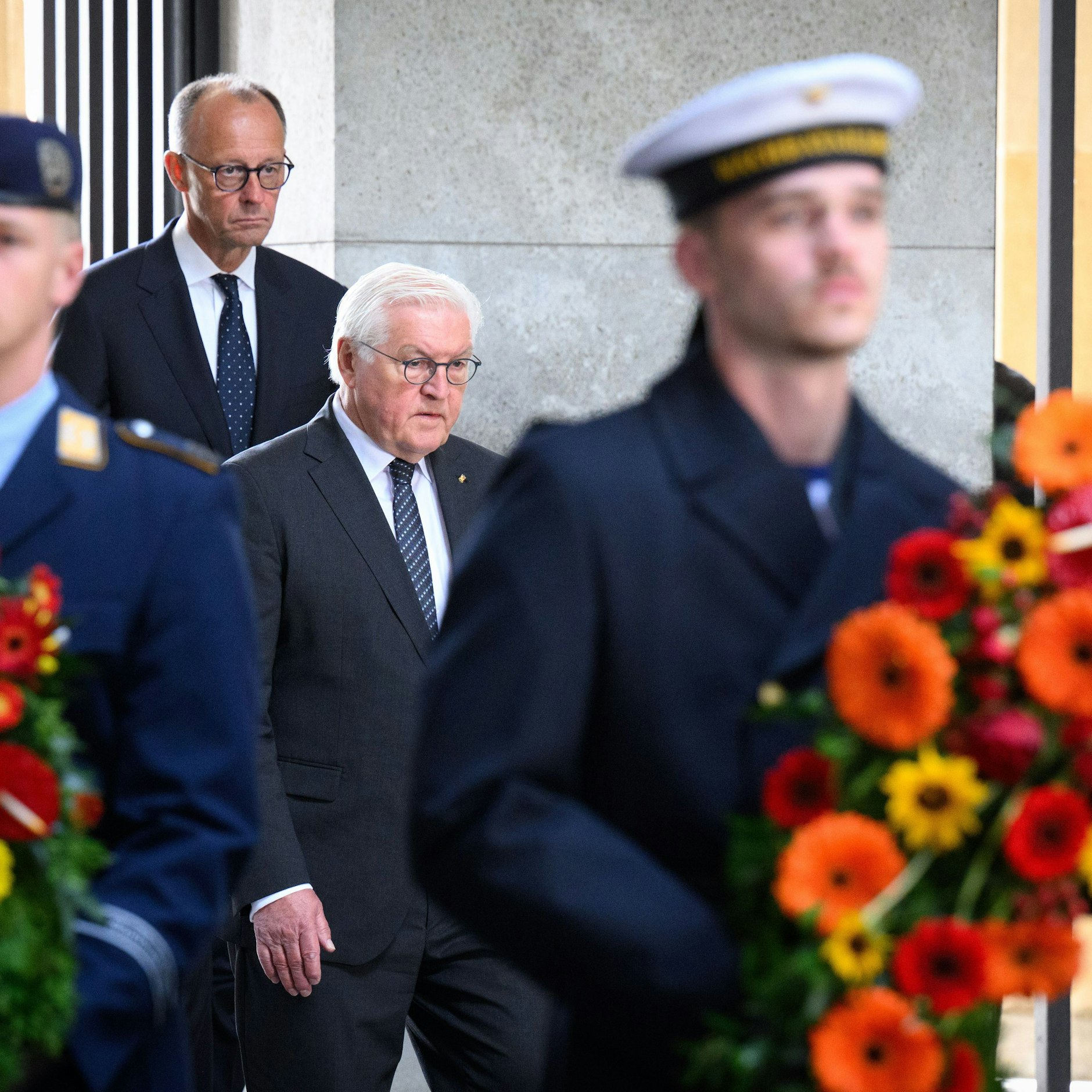 Bundespräsident Frank-Walter Steinmeier (M) und Bundeskanzler legen einen Kranz nieder.