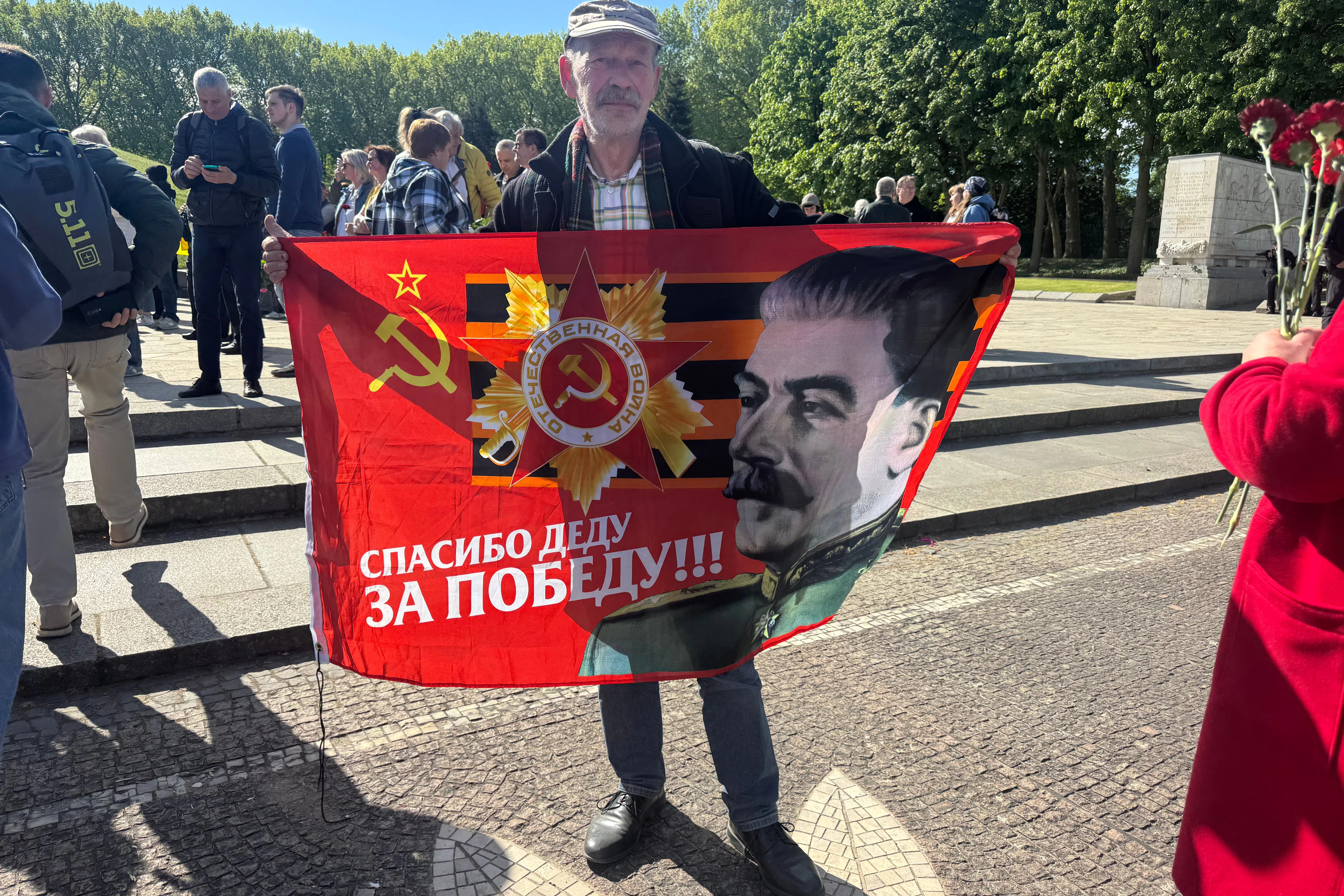 Ein Demonstrant hält in Berlin eine Stalin-Flagge hoch.