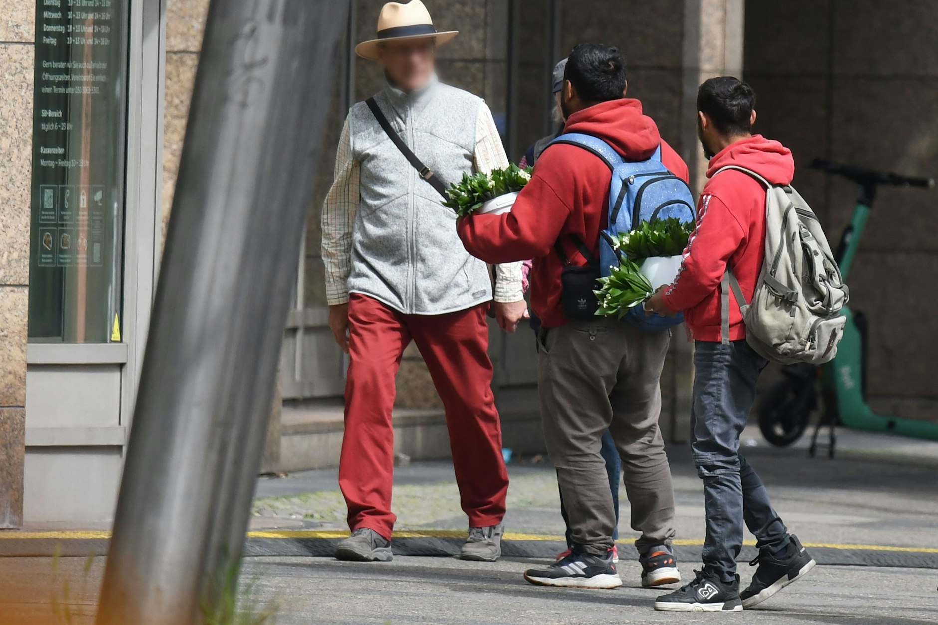 Diese Maiglöckchen-Verkäufer Charlottenburg tragen die Ware in Eimern mit sich. Höchstwahrscheinlich stammen sie aus Wäldern rund um Berlin.