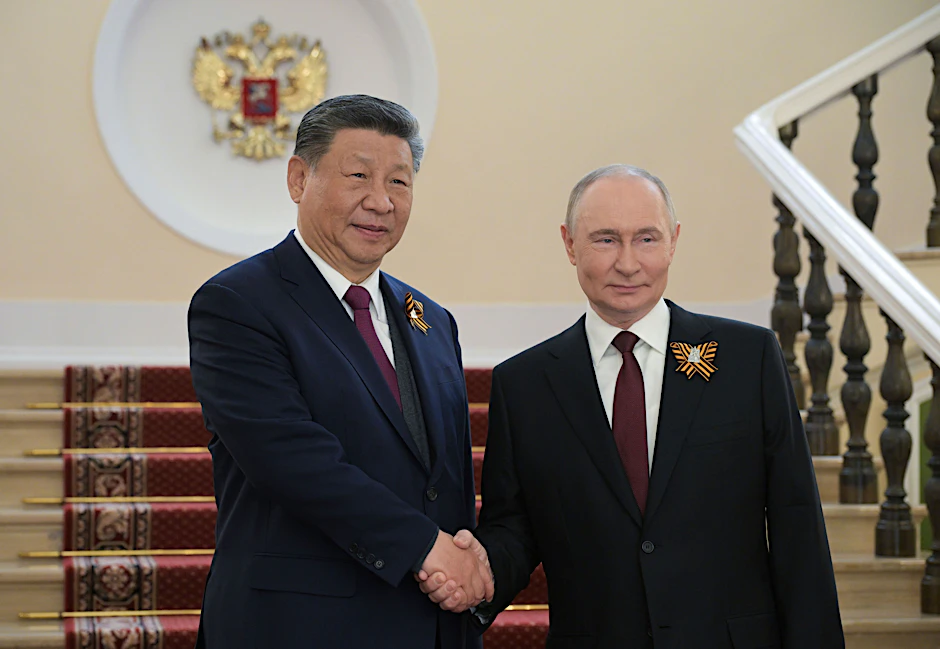Der chinesische Präsident Xi Jinping (l) und der russische Präsident Wladimir Putin schütteln sich während ihres Treffens vor der Militärparade zum Tag des Sieges die Hände.