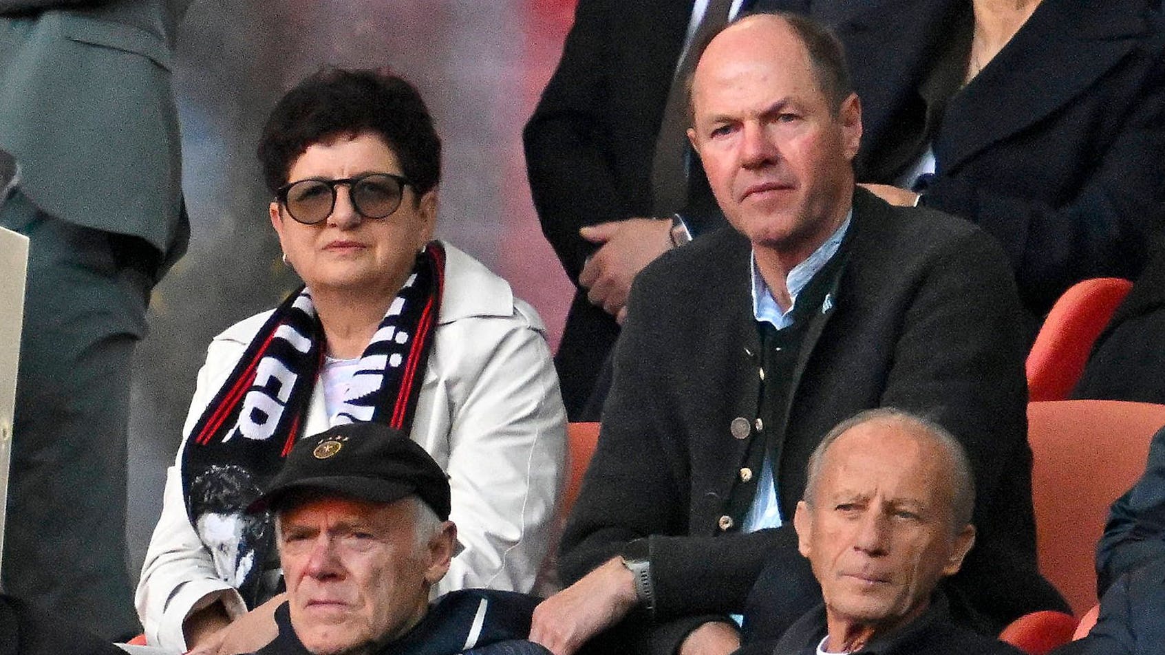 Die Eltern von Thomas Müller, Mama Klaudia und Vater Gerhard sitzen auf der Tribüne hinter Trainer-Urgestein Hermann Gerland.