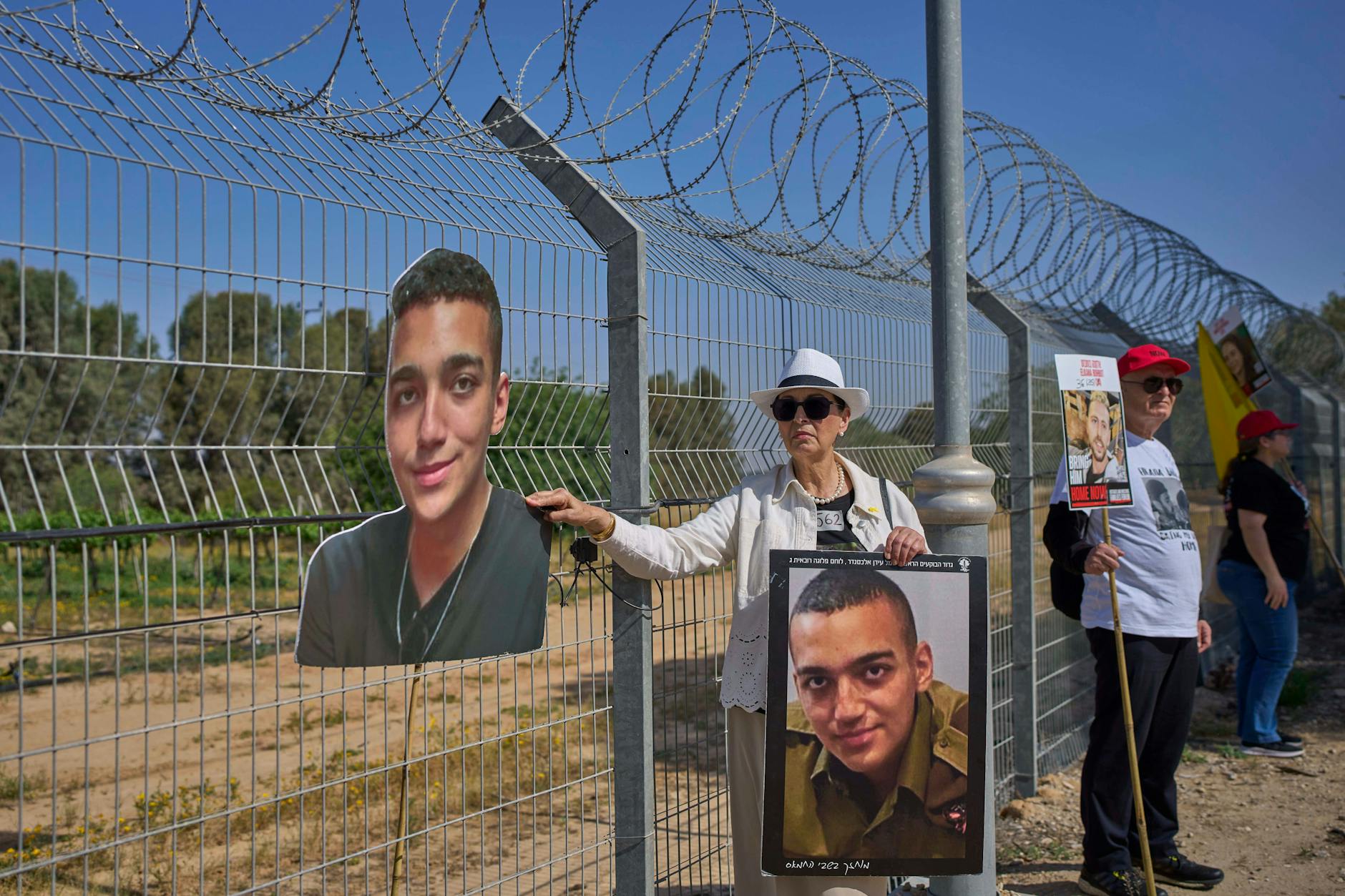 Varda Ben Baruch hält an der Grenze zum Gazastreifen im Kibbuz Nir Oz, Südisrael, Bilder ihres Enkels Edan Alexander, der seit 7. Oktober 2023 im Gazastreifen als Geisel festgehalten wird, hoch.