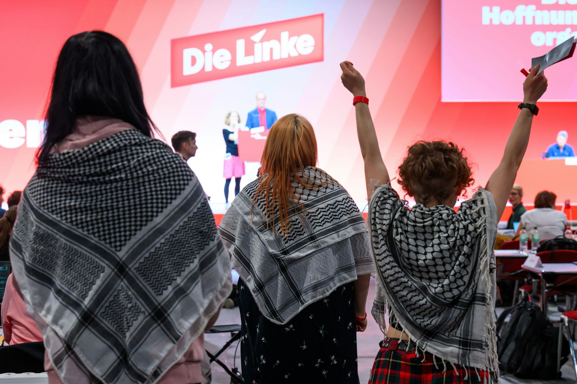 Delegierte mit sogenannten Palästinensertüchern sind auf dem Bundesparteitag der Partei Die Linke in Chemnitz im Saal.