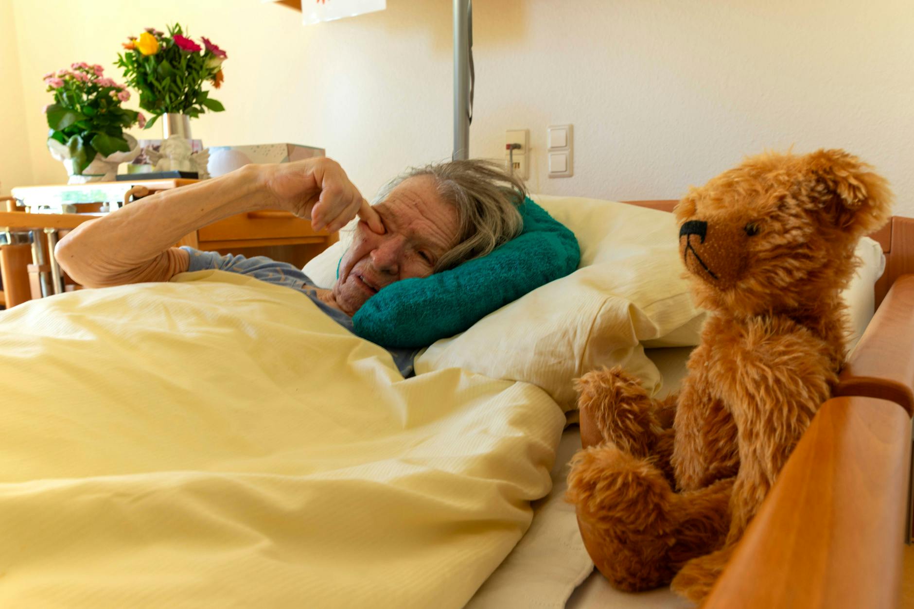 Eine an Demenz erkrankte Frau liegt in ihrem Bett in einem Pflegeheim (Symbolfoto). In vielen Altenheimen gibt es zu wenig Personal, weil Tausende Pflegekräfte fehlen.