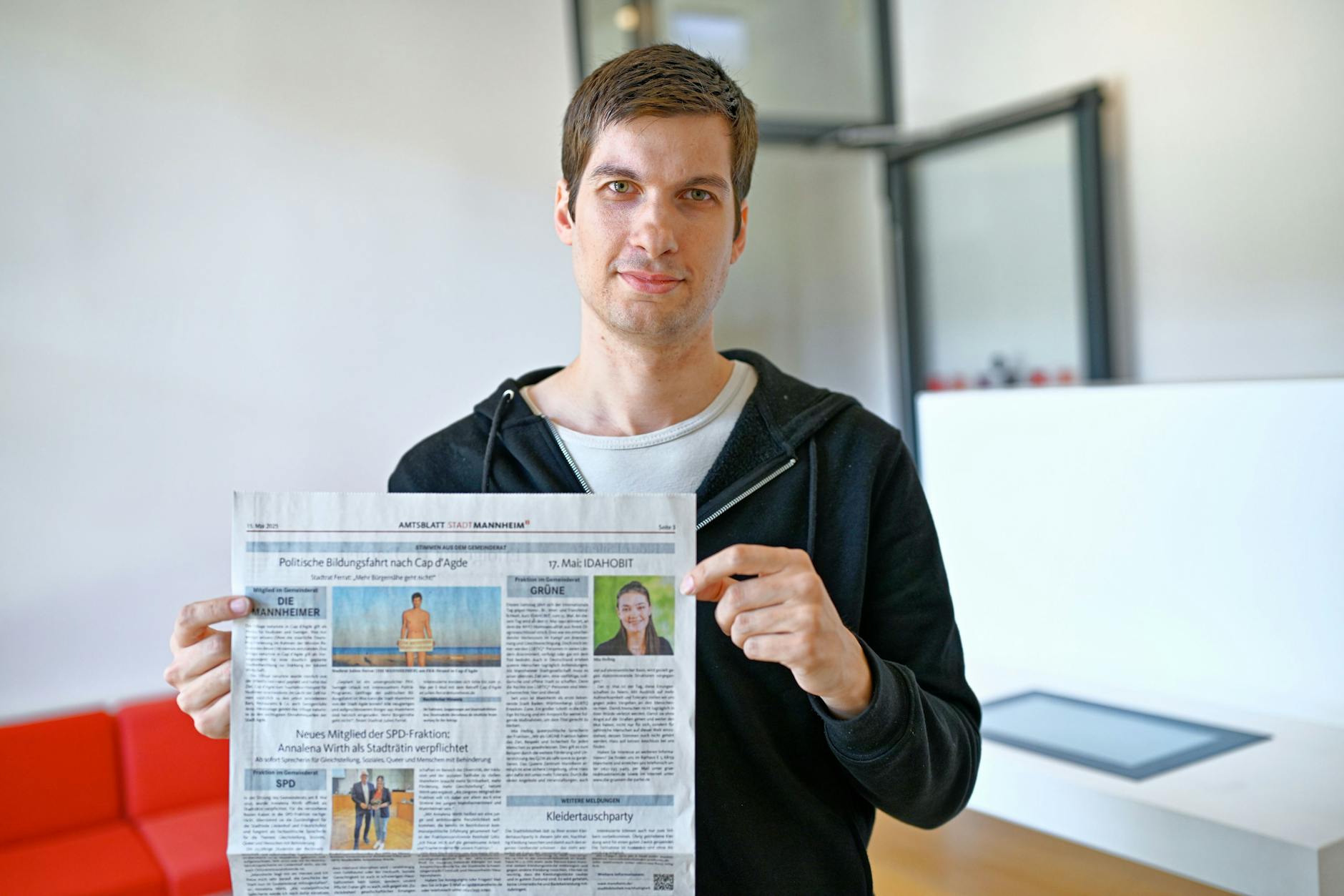 Julien Ferrat, Stadtrat der Mannheimer Wählervereinigung „Die Mannheimer“, hält ein Amtsblatt mit seinem Artikel in den Händen.