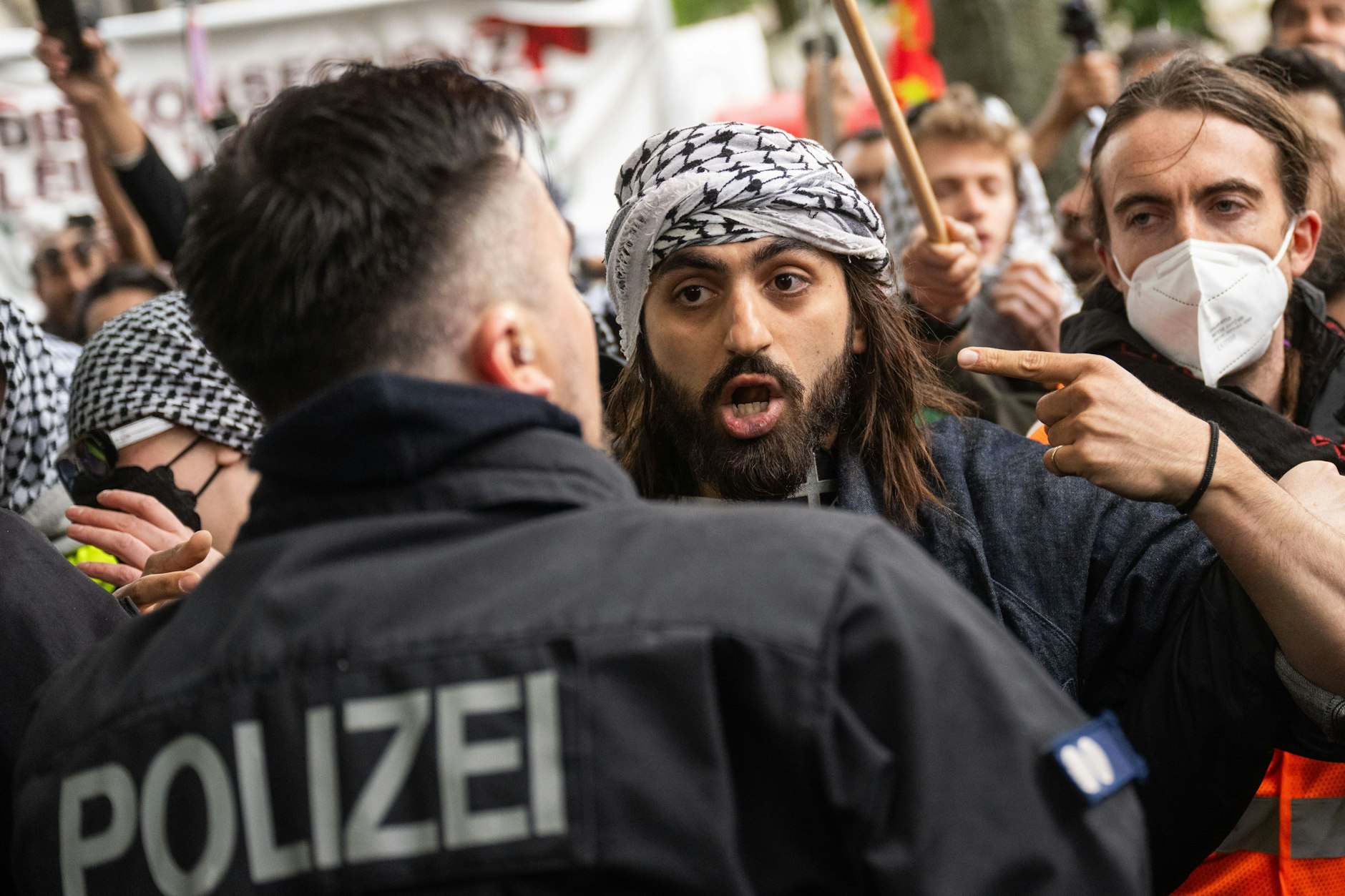 Ein Teilnehmer diskutiert bei der propalästinensischen Demonstration zum 77. Nakba-Tag mit einem Polizisten.