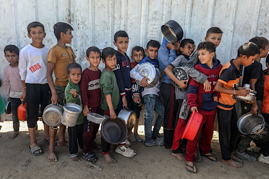 Palästinenser stehen an, um eine Mahlzeit vom Welternährungsprogramm und dem Hilfswerk der Vereinten Nationen für Palästinaflüchtlinge im Nahen Osten (UNRWA) zu erhalten.