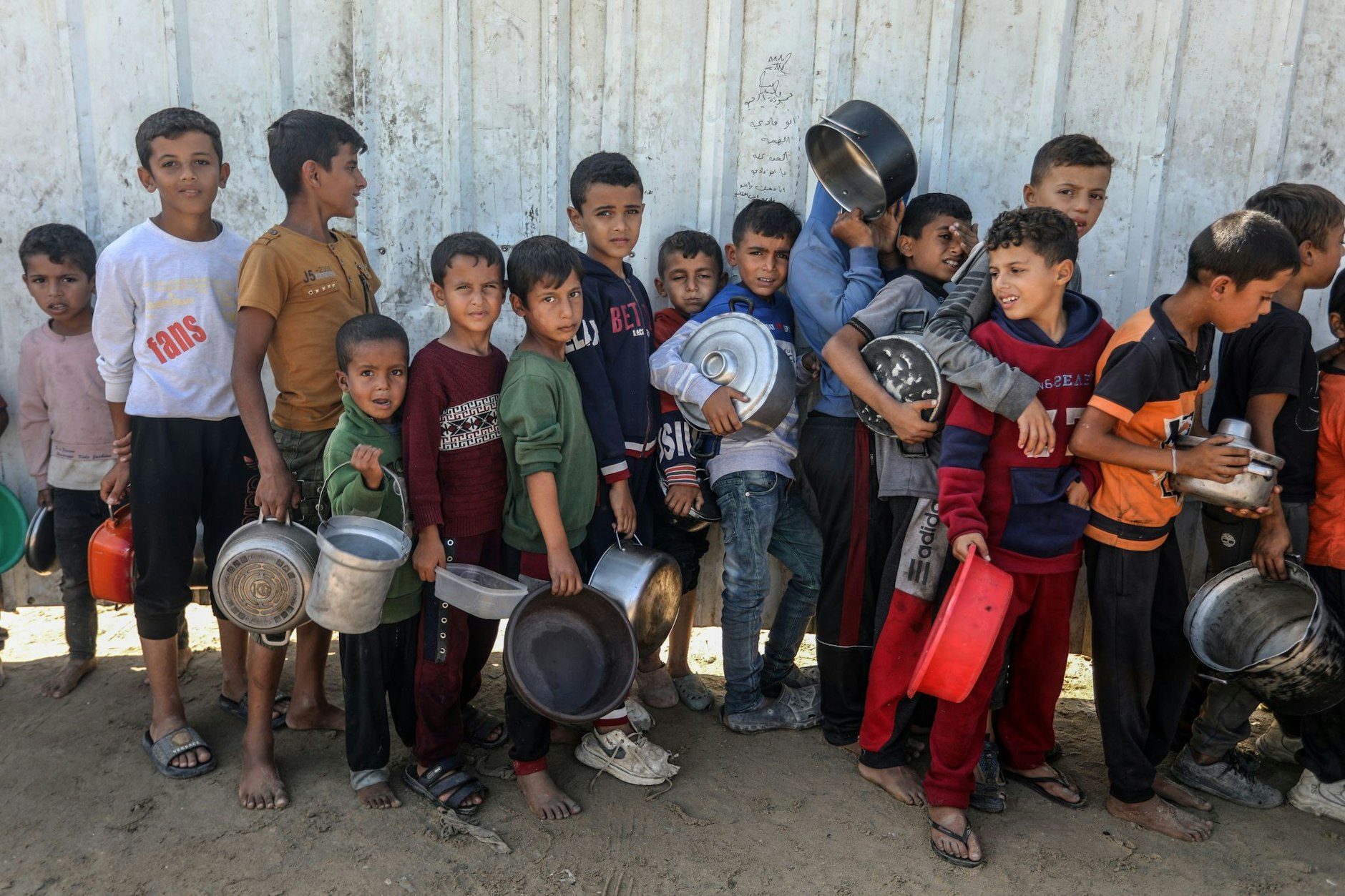 Palästinenser stehen an, um eine Mahlzeit vom Welternährungsprogramm und dem Hilfswerk der Vereinten Nationen für Palästinaflüchtlinge im Nahen Osten (UNRWA) zu erhalten.