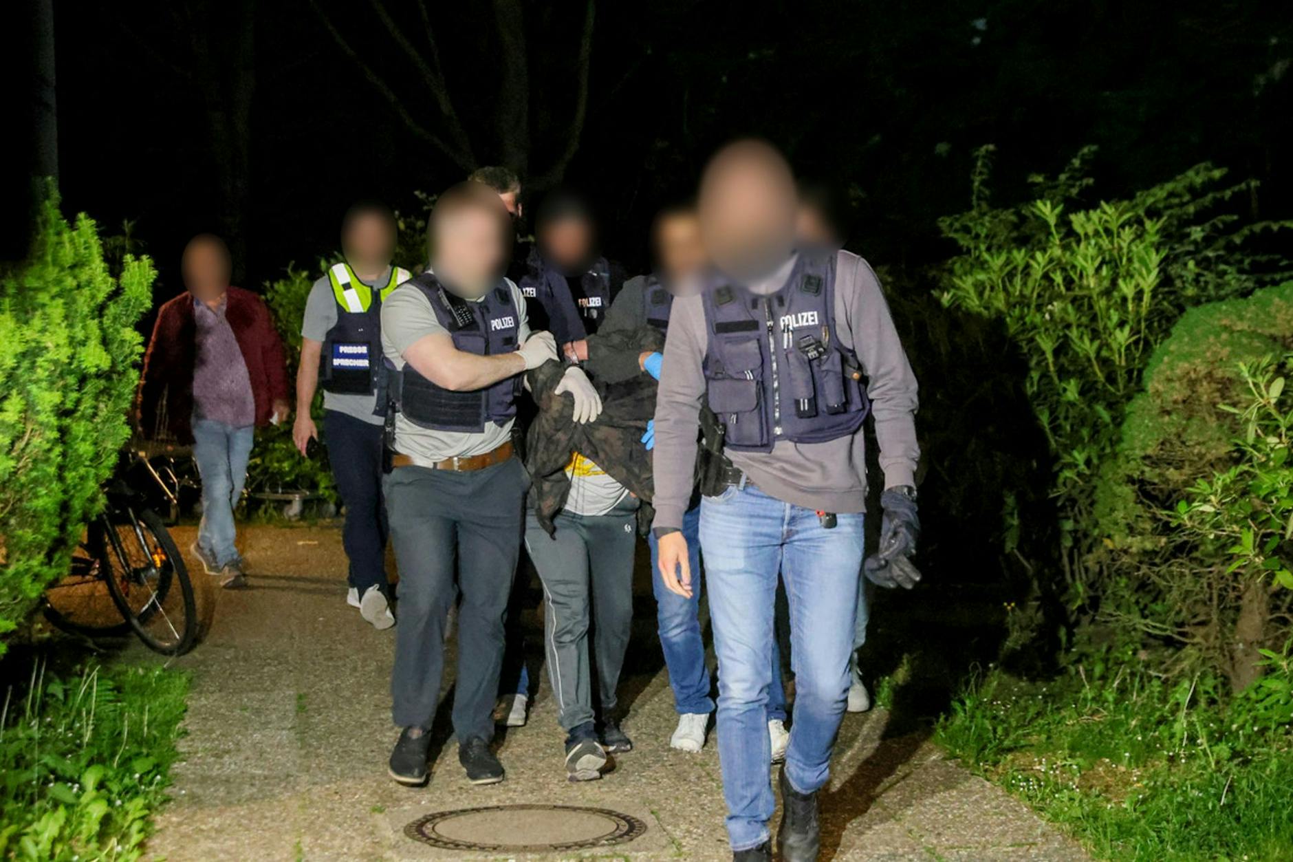 Einsatzkräfte der Polizei führen den Tatverdächtigen nach seiner Festnahme ab.