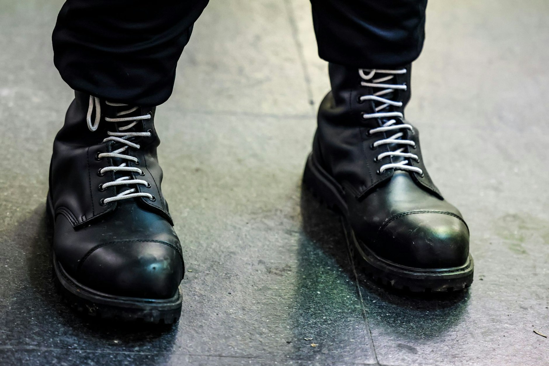 Ein Teilnehmer einer rechtsextremen Kundgebung trägt schwarze Springerstiefel mit weißen Schnürriemen. 