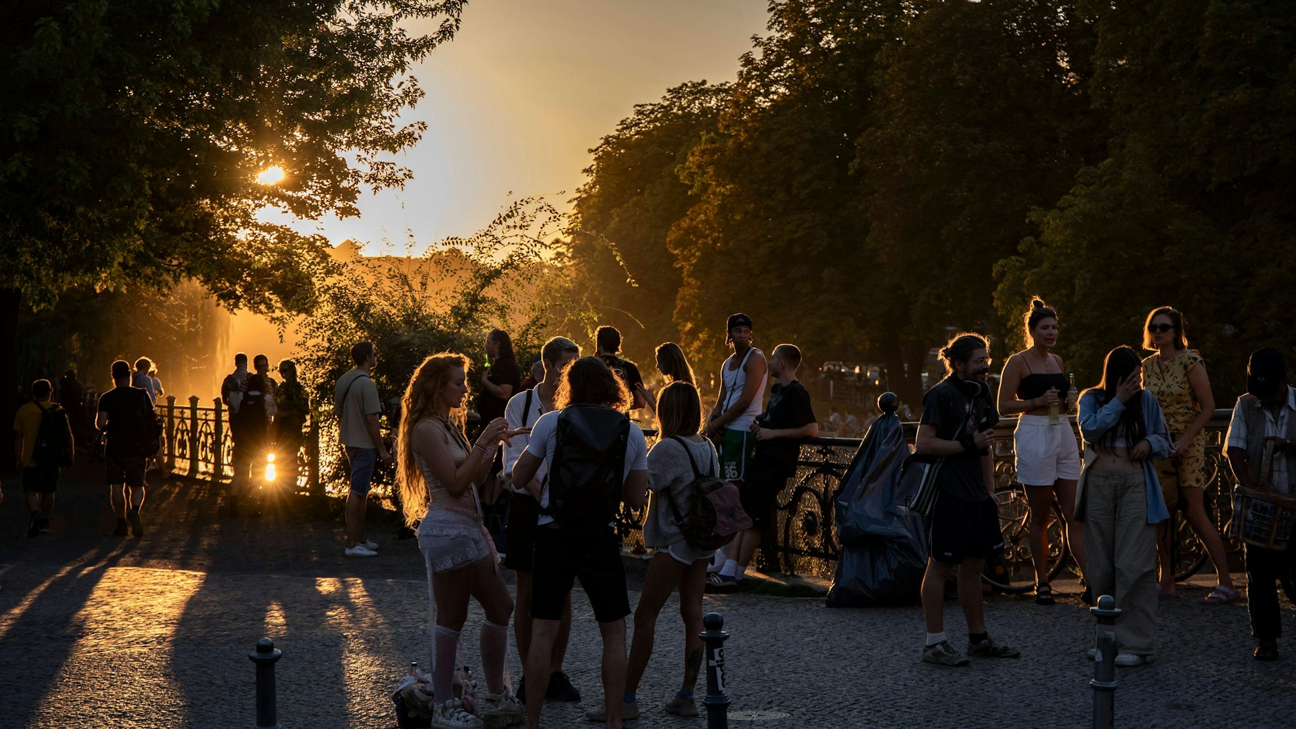 Menschen genießen einen sonnigen und warmen Sommertag auf der Admiralbrücke in Kreuzberg.