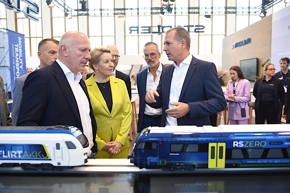 Kai Wegner (l.) und Franziska Giffey hinter einem Zugmodell am Stand von Stadler.