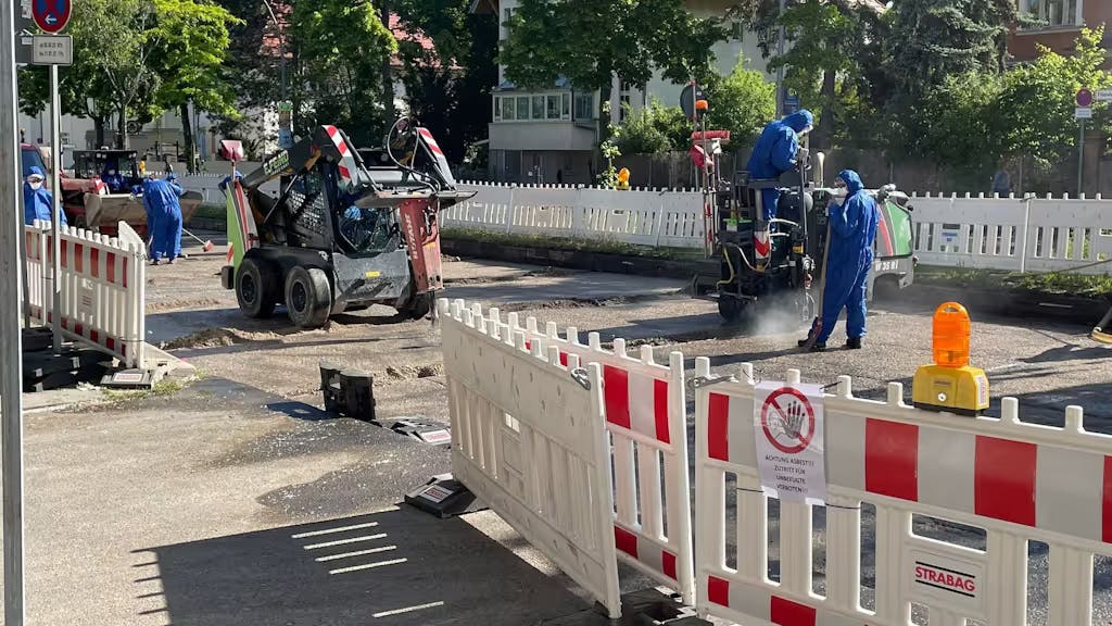 Mit Schutzanzügen und Atemschutzmasken arbeiten Arbeiter auf einer Asbest-Baustelle in Berlin-Steglitz.