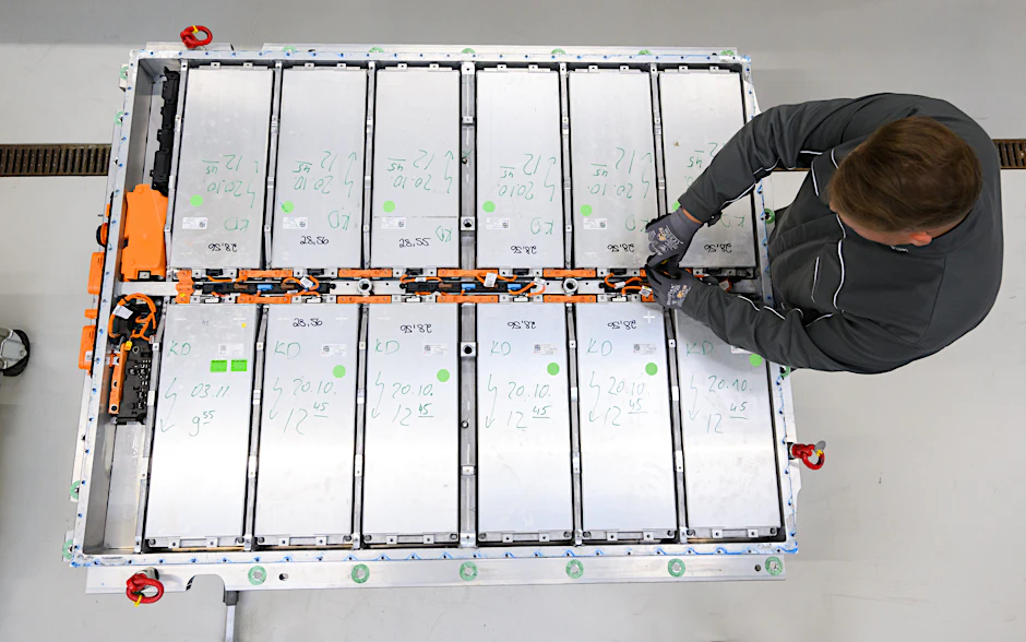 Ein Mitarbeiter entnimmt Batteriemodule aus einer ausgedienten Batterie eines Elektroautos im Batterie-Recycling im VW-Werk Salzgitter.