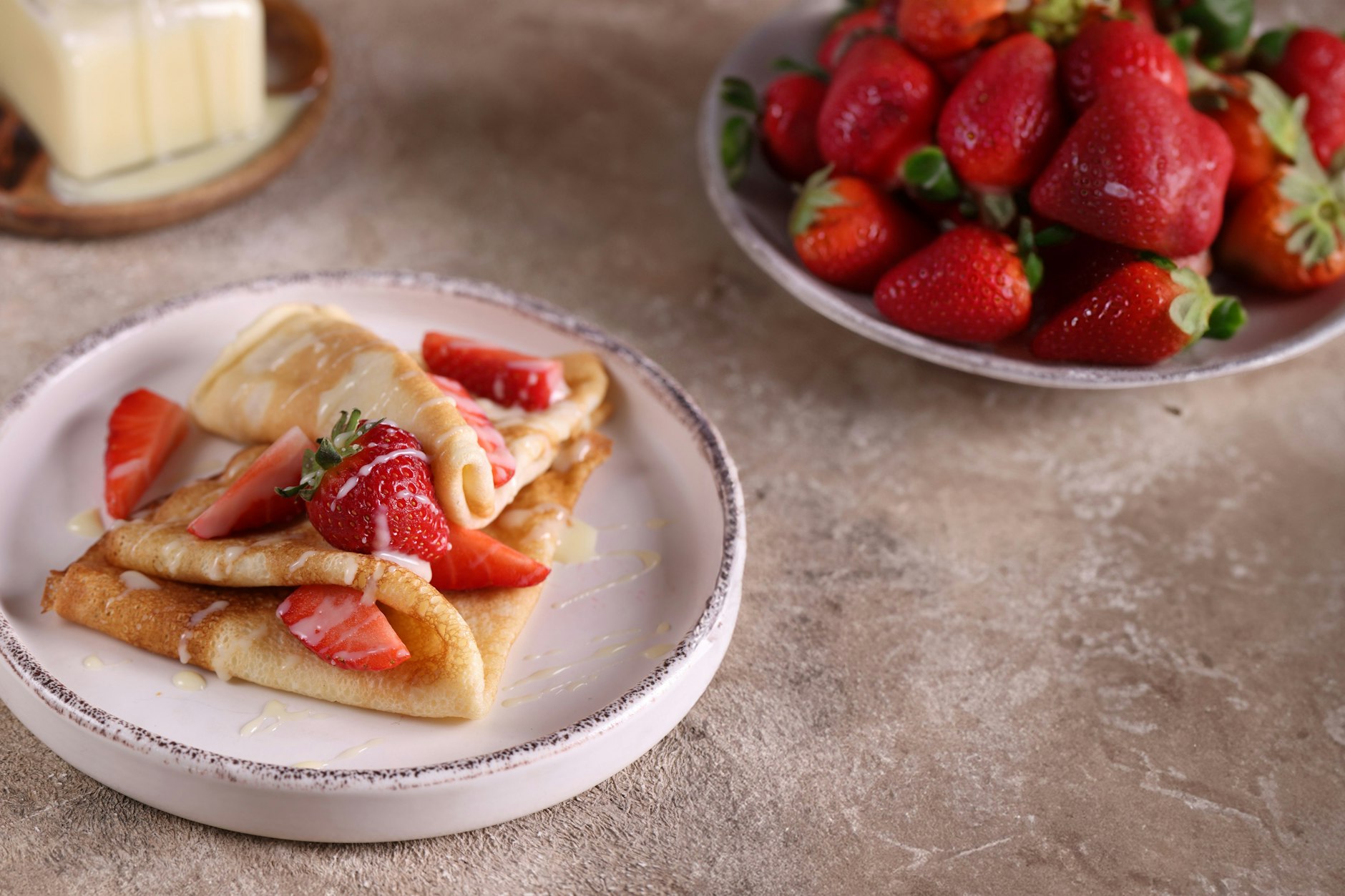 Eierkuchen sind mit frischen Erdbeeren und Vanillesoße ein köstliches Dessert.