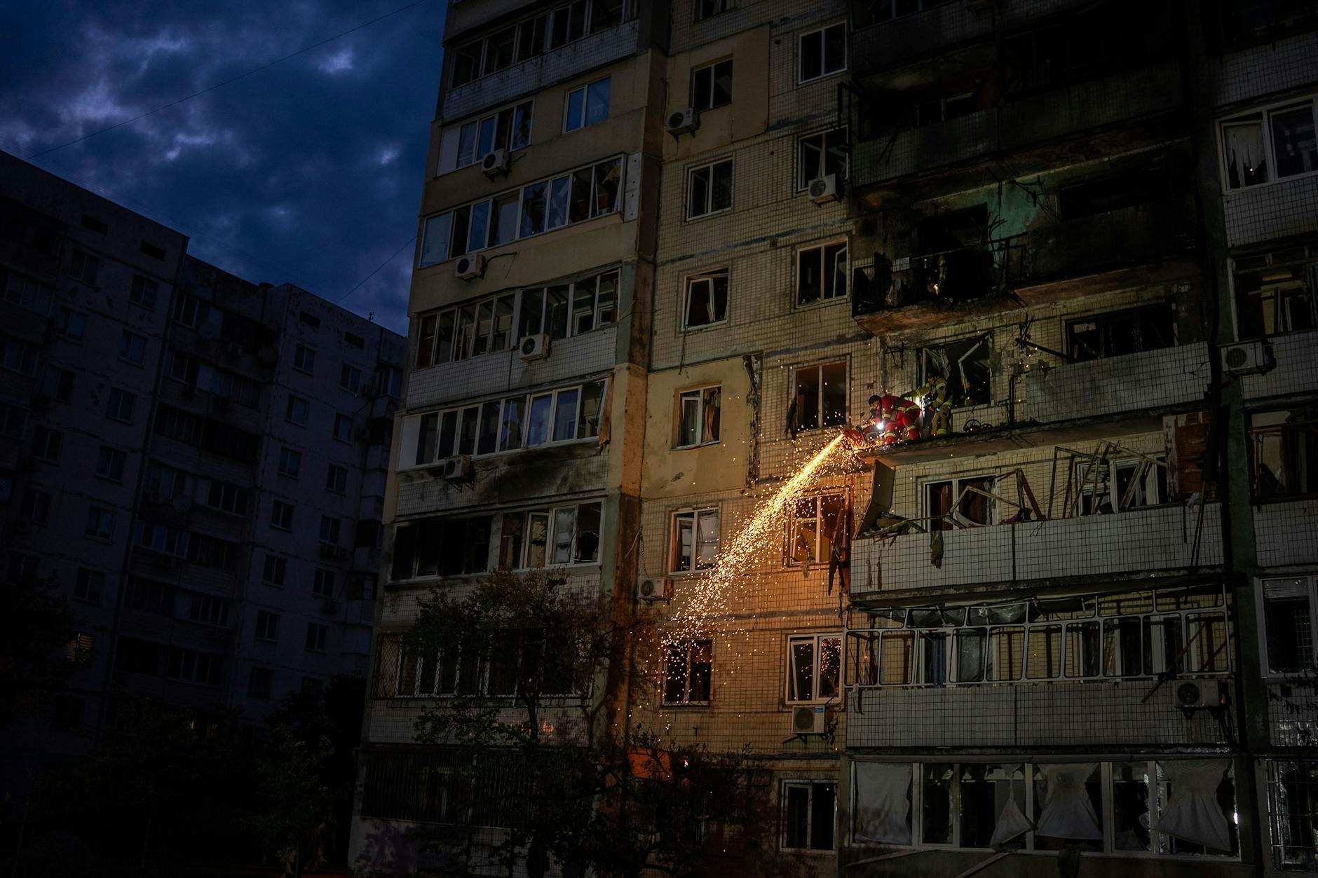 Ukraine, Kiew: Feuerwehrleute räumen Trümmer von einem Balkon eines Wohnhauses, das in der Nacht zu Samstag durch einen russischen Angriff beschädigt wurde.