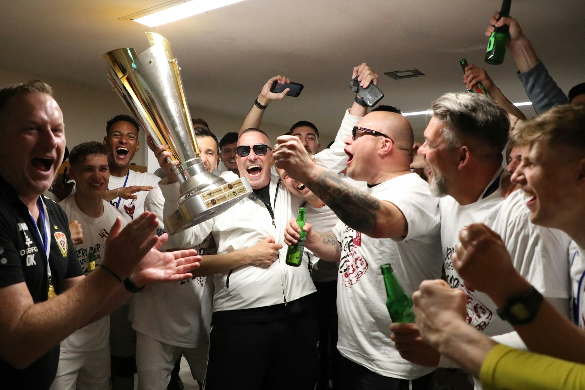 Da ist das Ding: Bei der Feier mit dem Pokal in der Kabine im Mommsenstadion wird auch BFC-Wirtschaftsrats-Boss Peter Meyer (M.) zum Feierbiest.