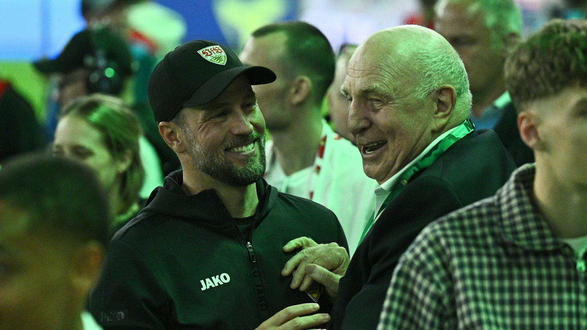 Trainer Sebastian Hoeneß (l) und sein Vater Dieter Hoeneß freuen sich bei grüner Beleuchtung vor der Siegerehrung.