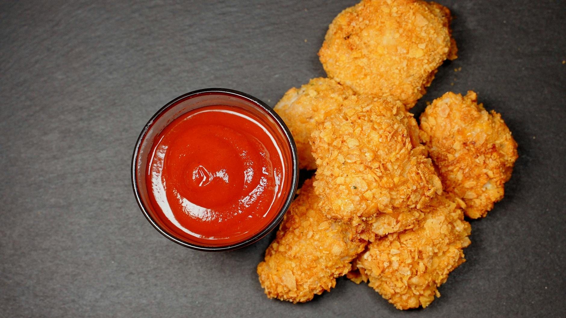 Die Hähnchenstücke werden mit Panko-Mehl besonders kross und schmecken köstlich mit Ketchup.
