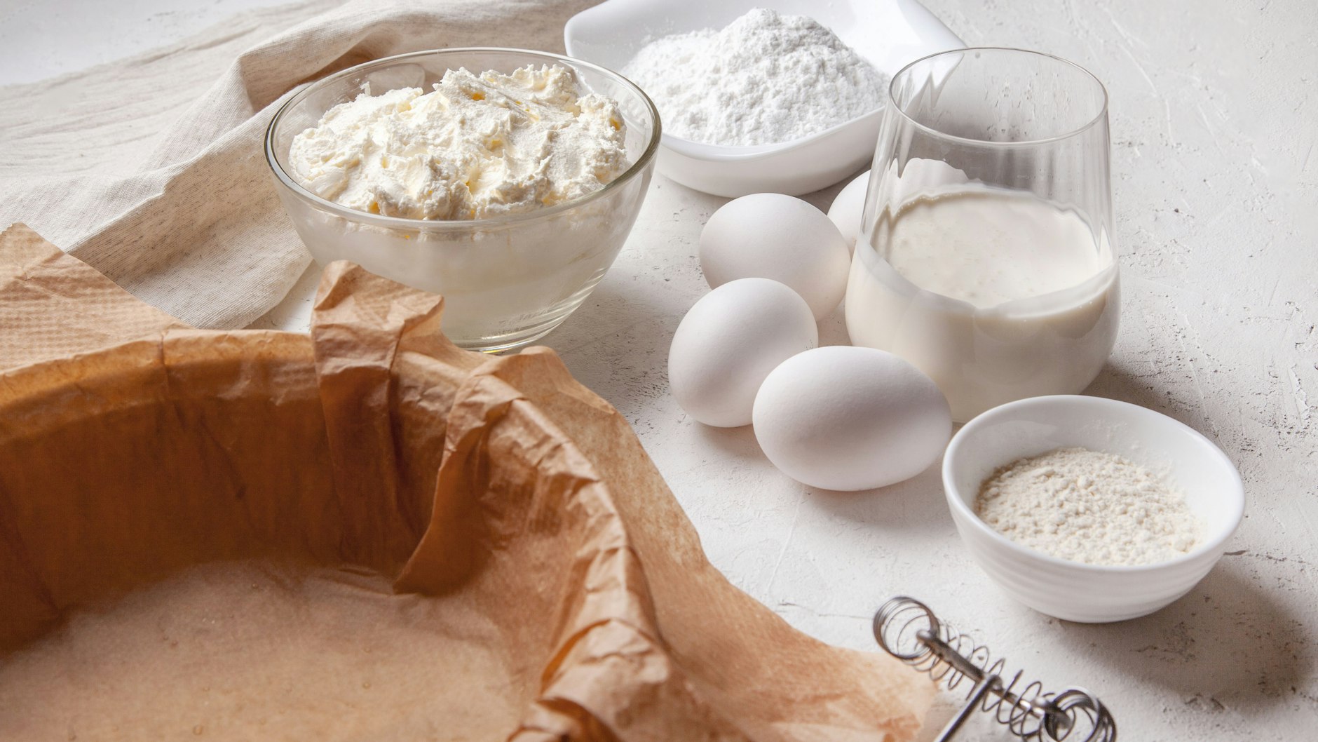 Der San Sebastian Käsekuchen muss mit Backpapier gebacken werden. Das Papier geht über den Springformrand.
