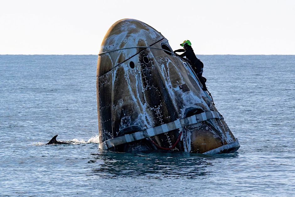 Ein Mitglied des Support-Teams arbeitet an der SpaceX-Kapsel „Crew Dragon“ kurz nach einer Landung
