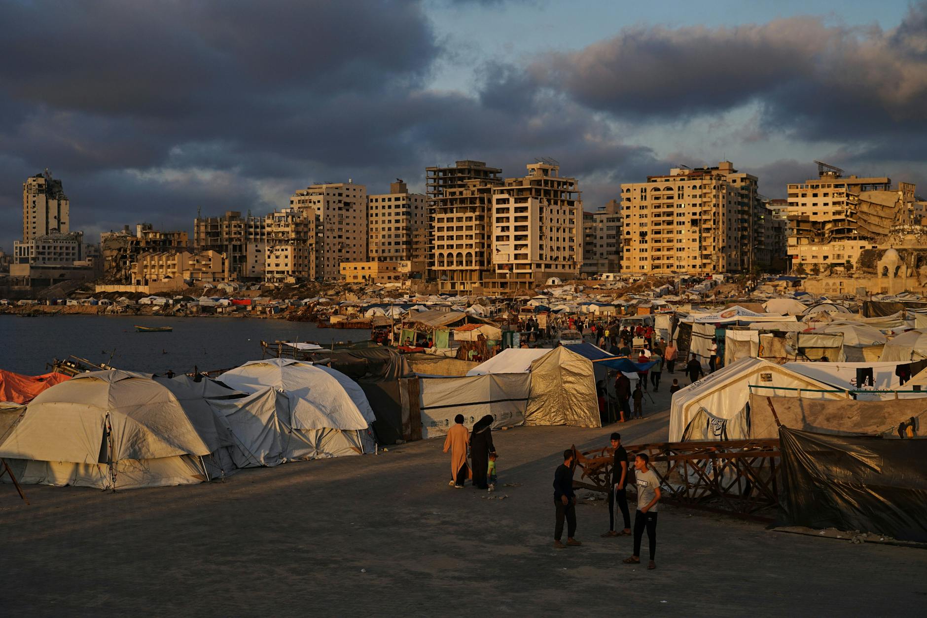 Palästinensische Gebiete, Gaza-Stadt: Vertriebene Palästinenser gehen an einem behelfsmäßigen Zeltlager an der Küste entlang.