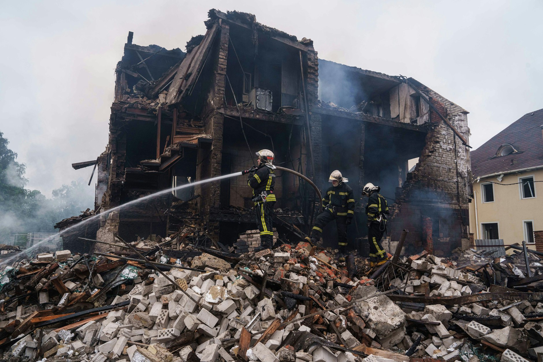 Ukraine, Markhaliwka: Rettungskräfte löschen am Sonntag, 25. Mai 2025 das Feuer eines durch einen russischen Angriff zerstörten Hauses im Dorf Markhaliwka in der Region um Kiew.
