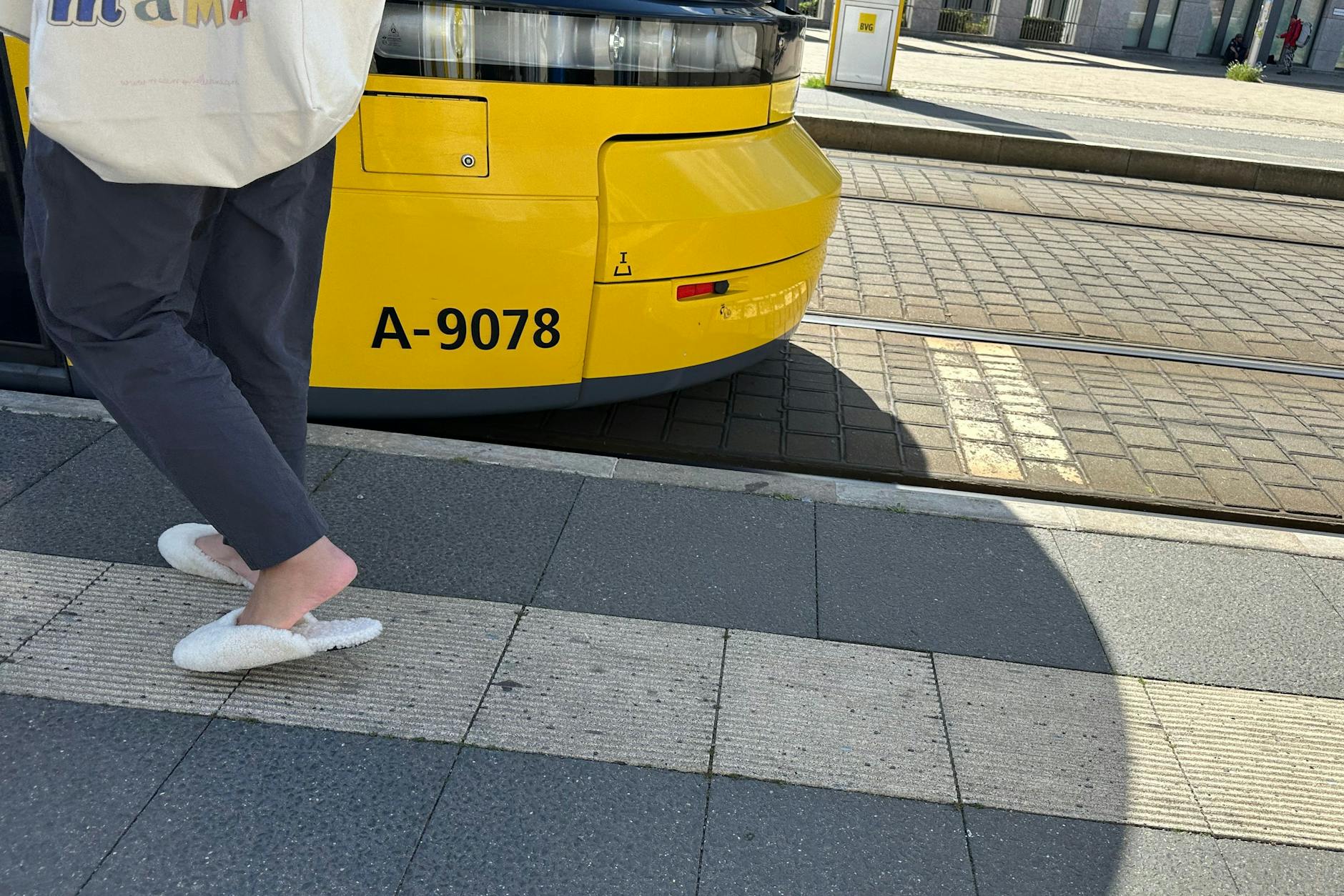 Vom Wohnzimmer auf die Straße: Lammfellschlappen an der Straßenbahnhaltestelle.