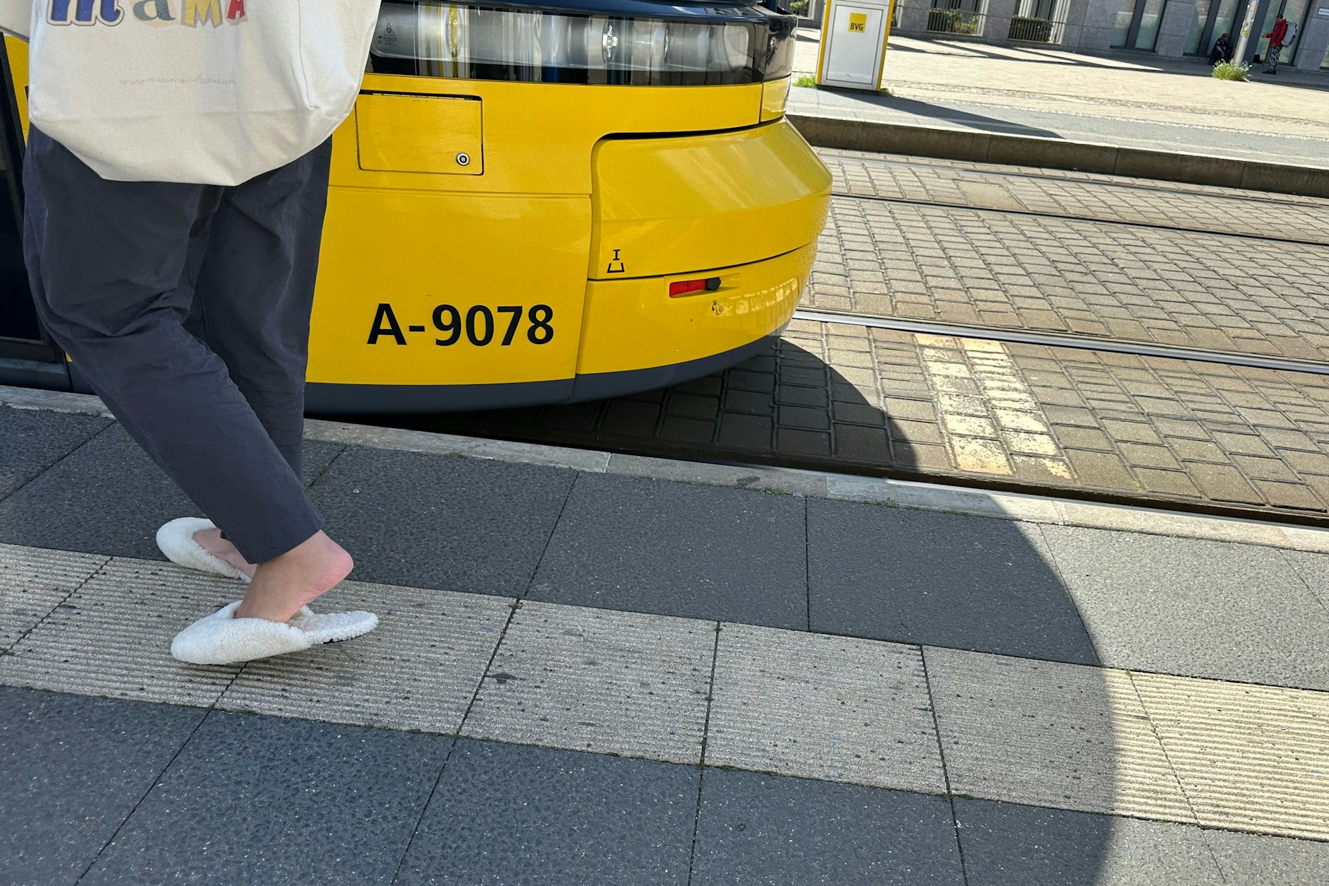 Vom Wohnzimmer auf die Straße: Lammfellschlappen an der Straßenbahnhaltestelle.