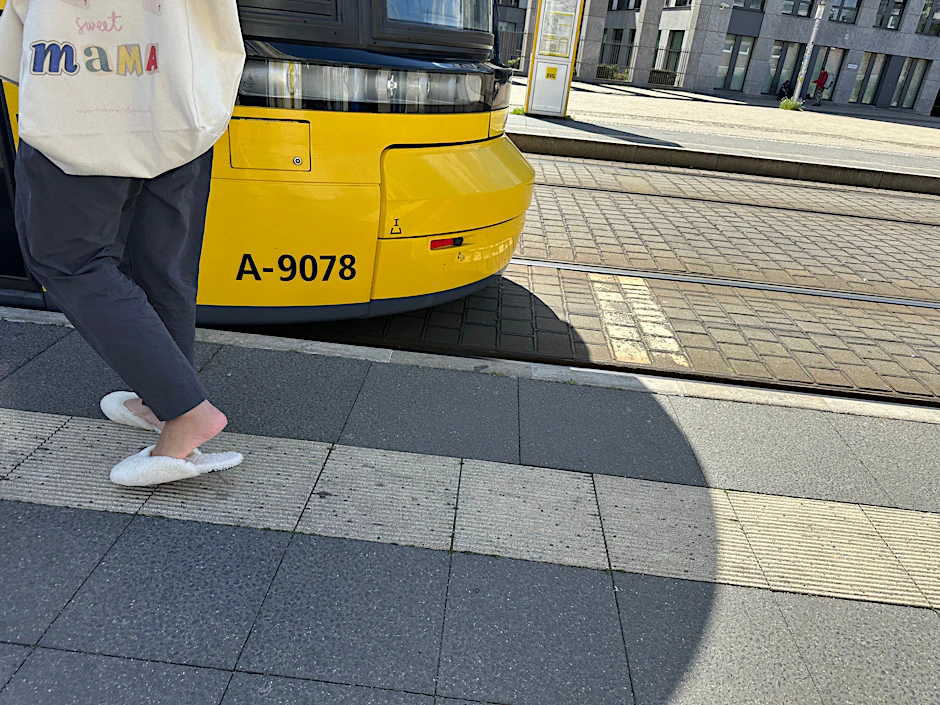 Vom Wohnzimmer auf die Straße: Lammfellschlappen an der Straßenbahnhaltestelle.