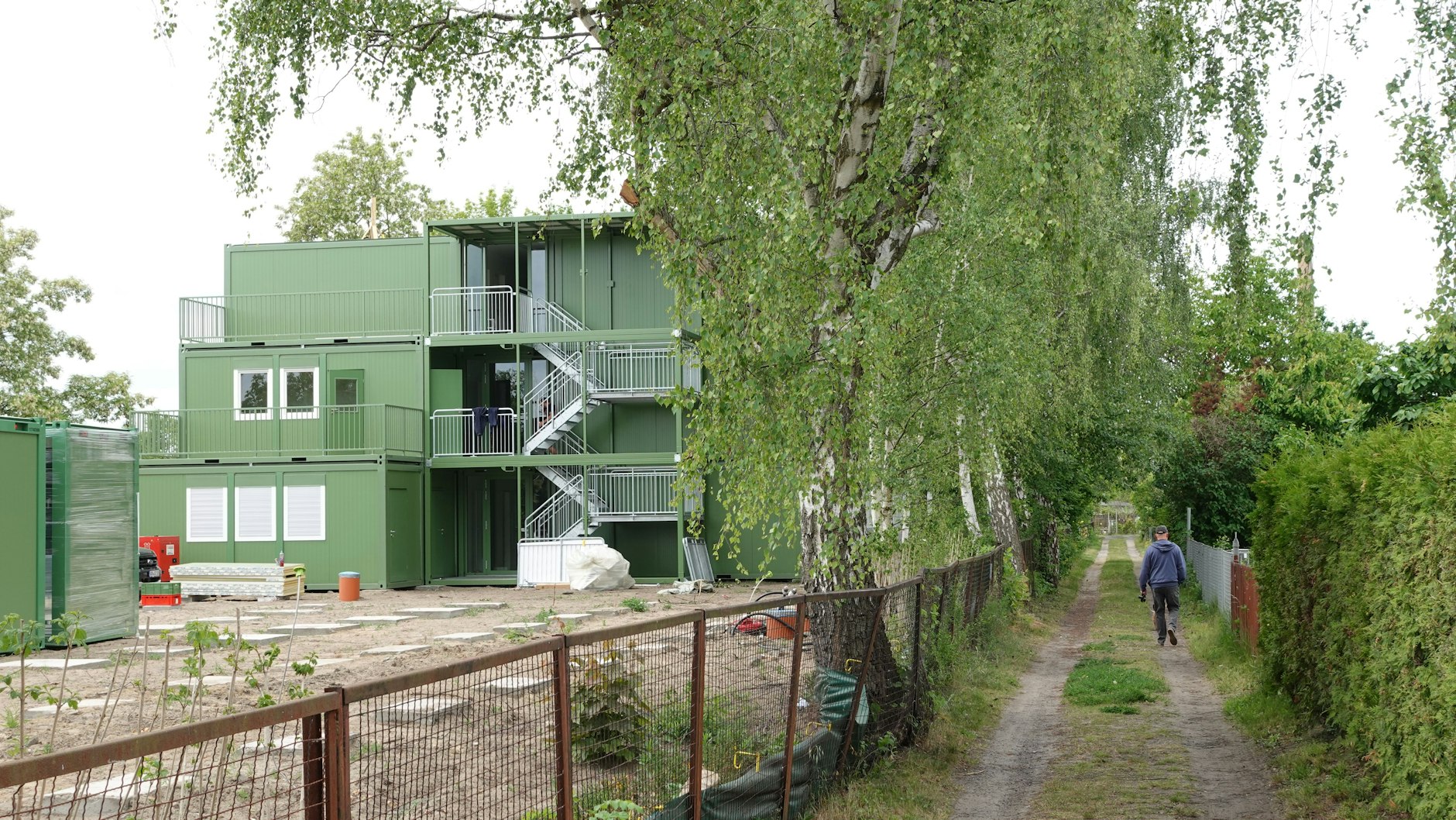 Nur ein schmaler Weg trennt Wohncontainer von den Kleingärten.