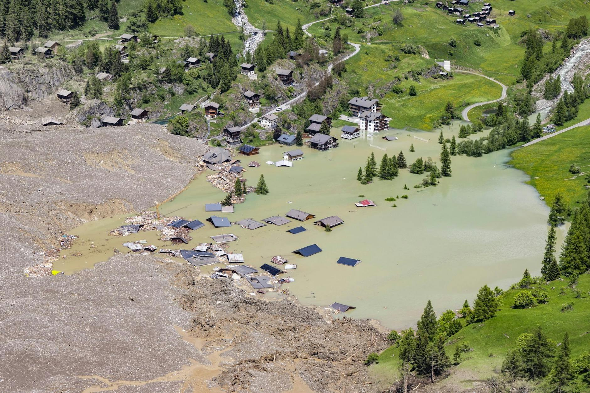 Eine Luftaufnahme, die einen Tag nach einer massiven Lawine, die durch den Abbruch des Birchgletschers ausgelöst wurde, aufgenommen wurde, zeigt einen See und die Zerstörung.