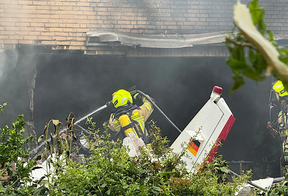 Die Feuerwehr arbeitet an der Absturzstelle, nachdem ein Flugzeug in ein Wohnhaus gestürzt ist.
