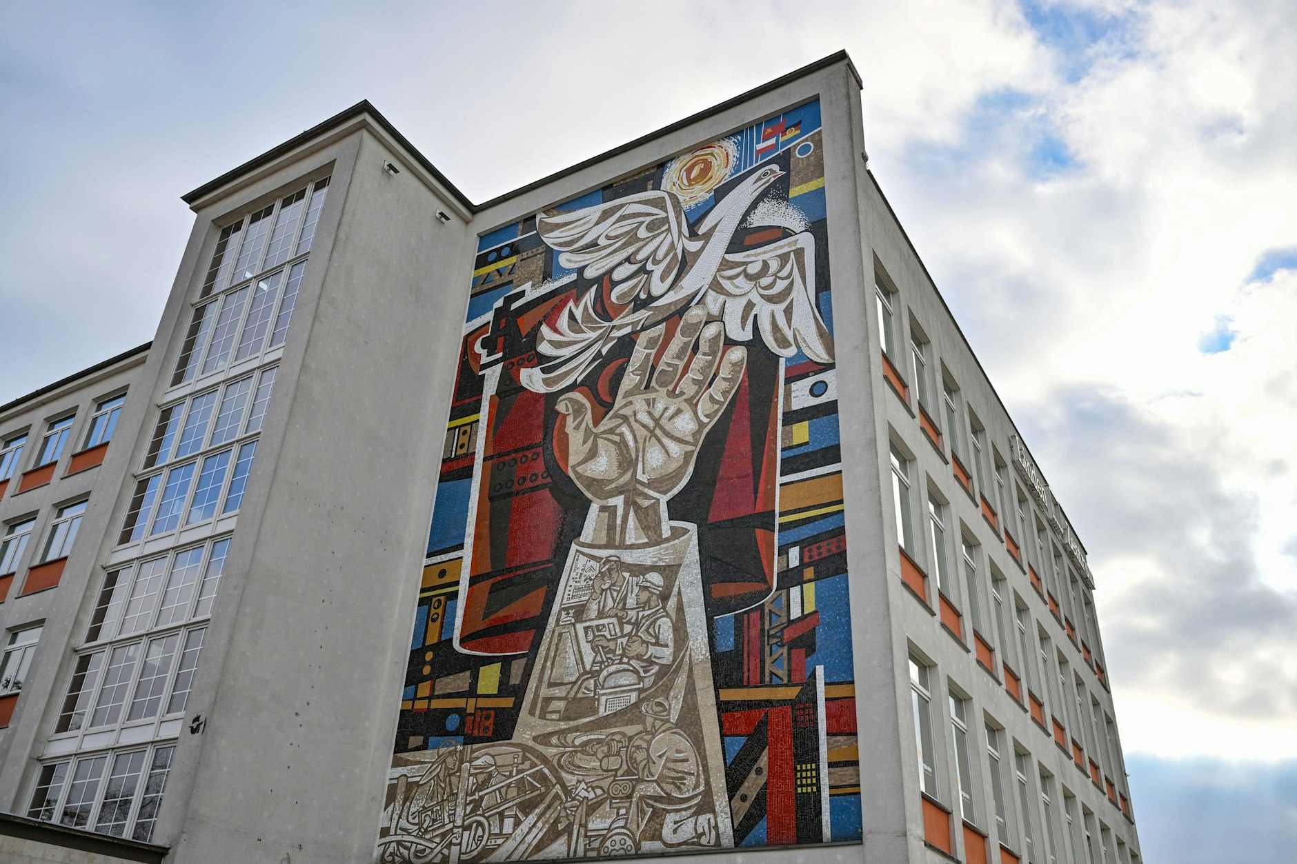 Eisenhüttenstadt: An einer Fassade eines ehemaligen Kaufhauses ist ein großes Mosaik-Kunstwerk von Walter Womacka (1925 - 2010) zu sehen.