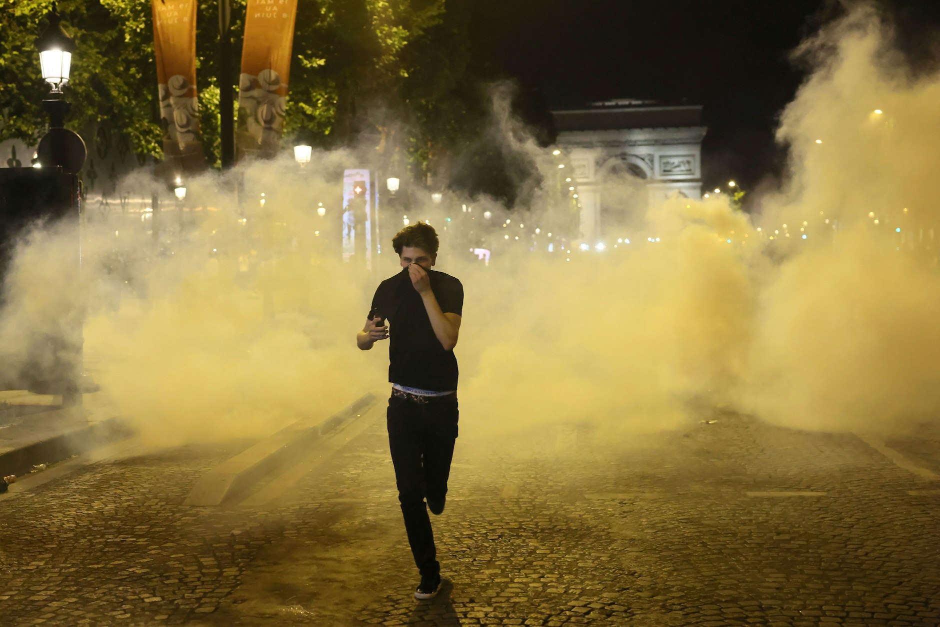 Ein Mann flieht vor Tränengas während der Zwischenfälle auf der Avenue des Champs-Élysées nach dem Champions-League-Finale zwischen PSG und Inter Milan.