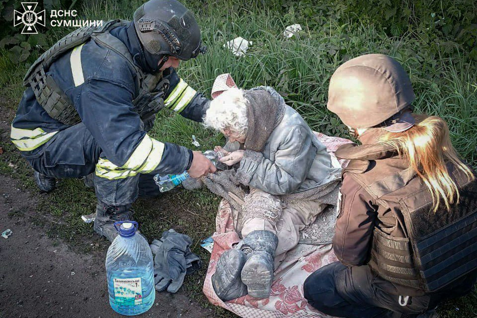Ukrainische Rettungskräfte leistet einer älteren Frau Hilfe, die nach einem russischen Angriff in der Region Sumy aus den Trümmern eines Hauses gerettet wurde.