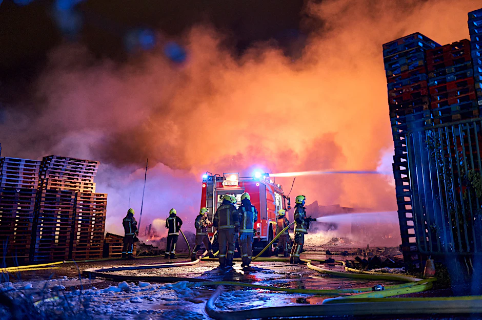 Einsatzkräfte der Feuerwehr löschen einen Brand auf einem Firmengelände in Berlin-Marzahn.