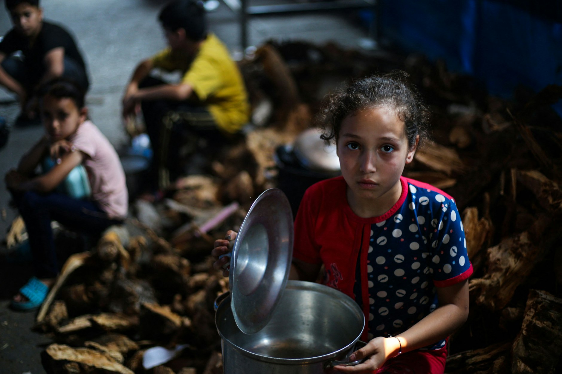 Im Flüchtlingslager Nuseirat im Gazastreifen warten palästinensische Kinder an einer Ausgabestelle auf Lebensmittel.