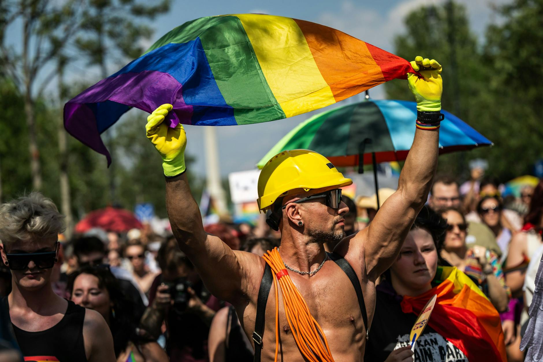 Ein Mann mit der Regenbogenflagge nimmt an der Pride-Parade teil.