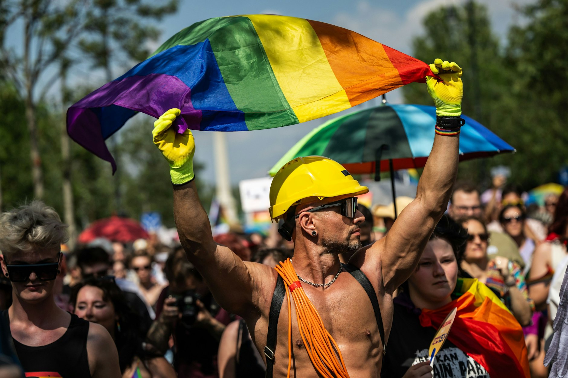 Ein Mann mit der Regenbogenflagge nimmt an der Pride-Parade teil.