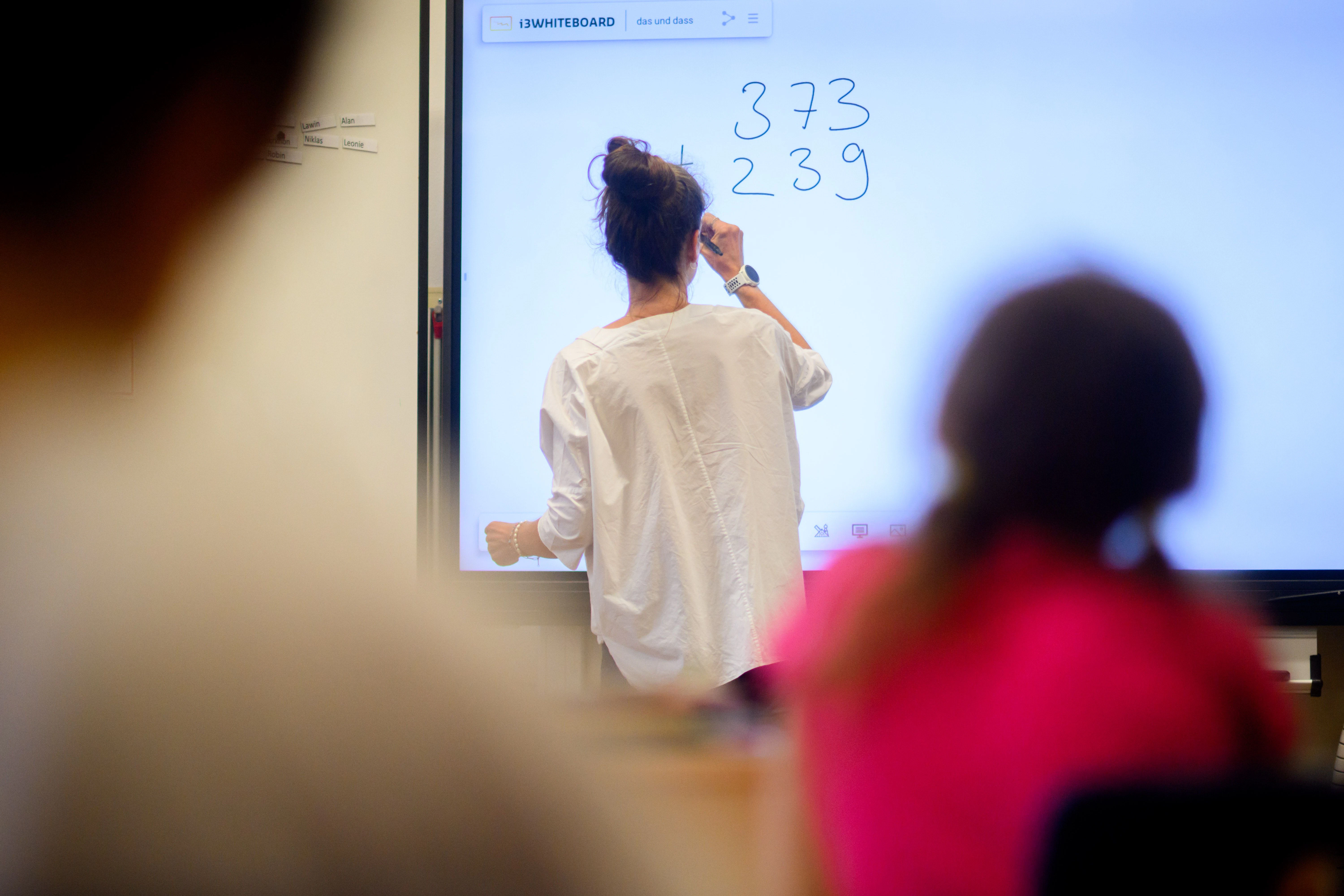 Hannover: Eine Lehrerin schreibt eine Mathematikaufgabe auf eine digitale Schultafel im Klassenraum.