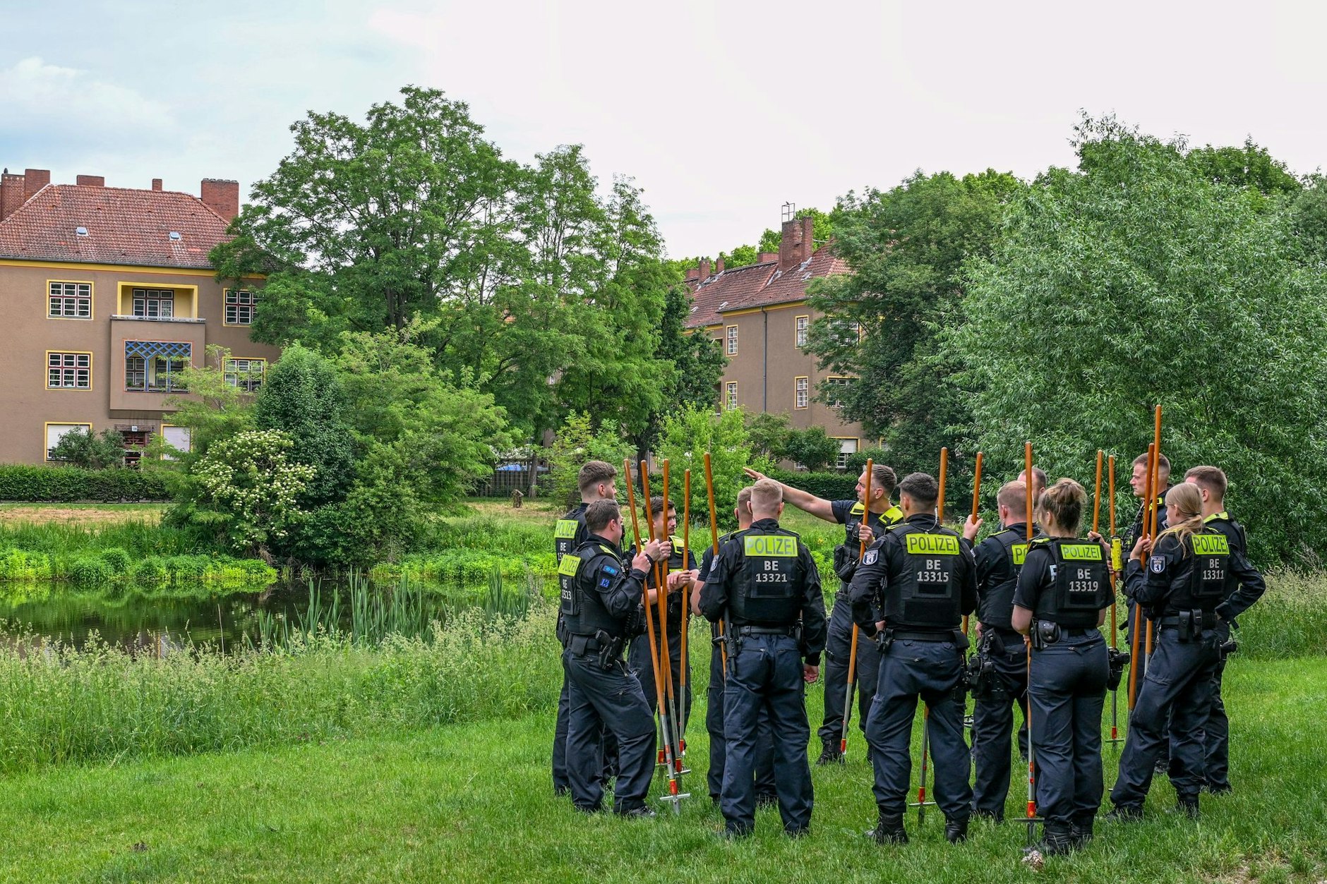 Polizeibeamte bekommen vor dem Absuchen des Ufers des Breitkopfbeckens in Reinickendorf Instruktionen.