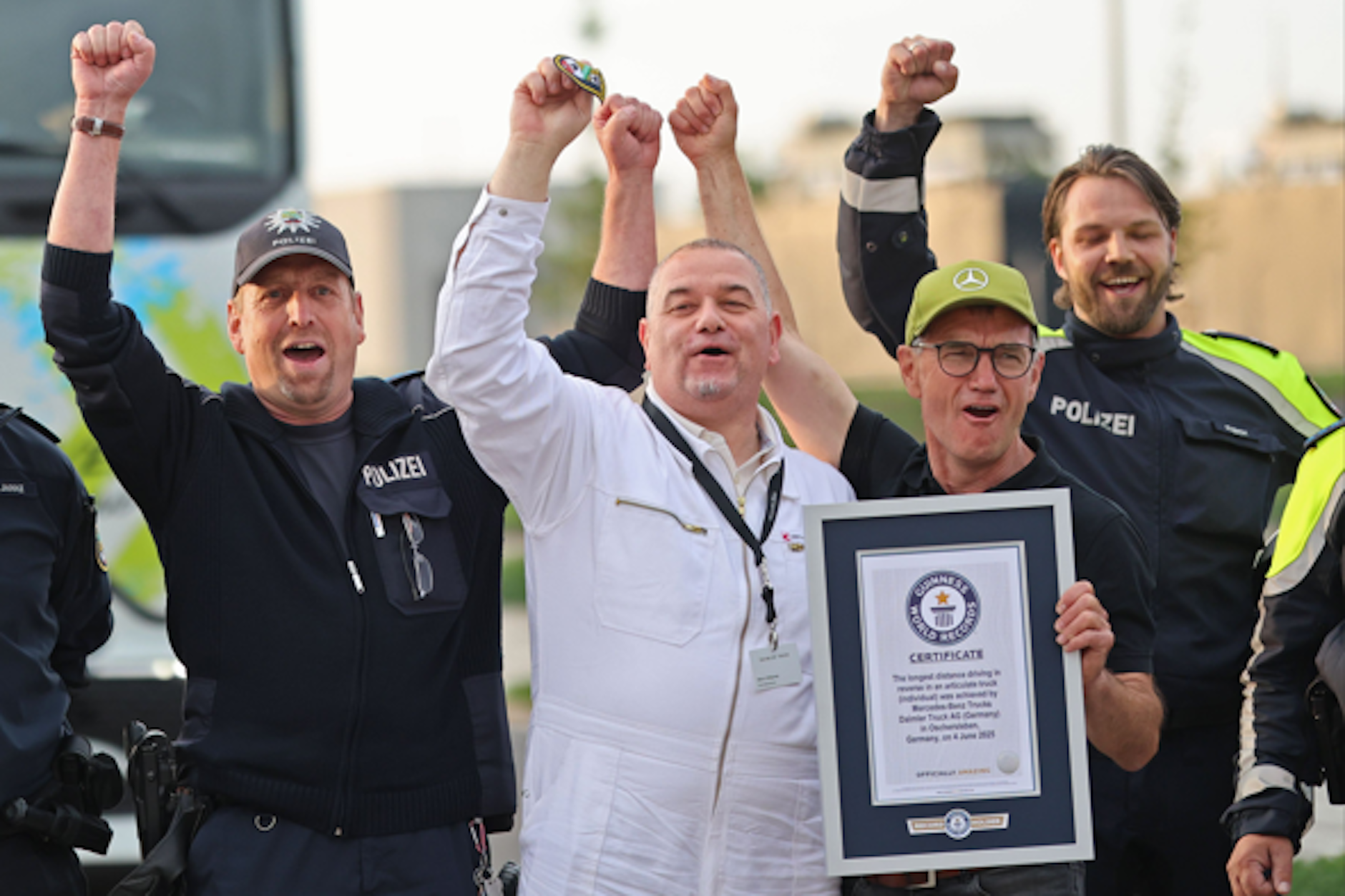 Weltmeister aus Werneuchen: Marco Hellgrewe triumphiert, er hat den neuen Rekord im Lkw-Rückwärtsfahren. Einsatzkräfte der Polizei jubeln mit ihm auf der Rennstrecke in Oschersleben.