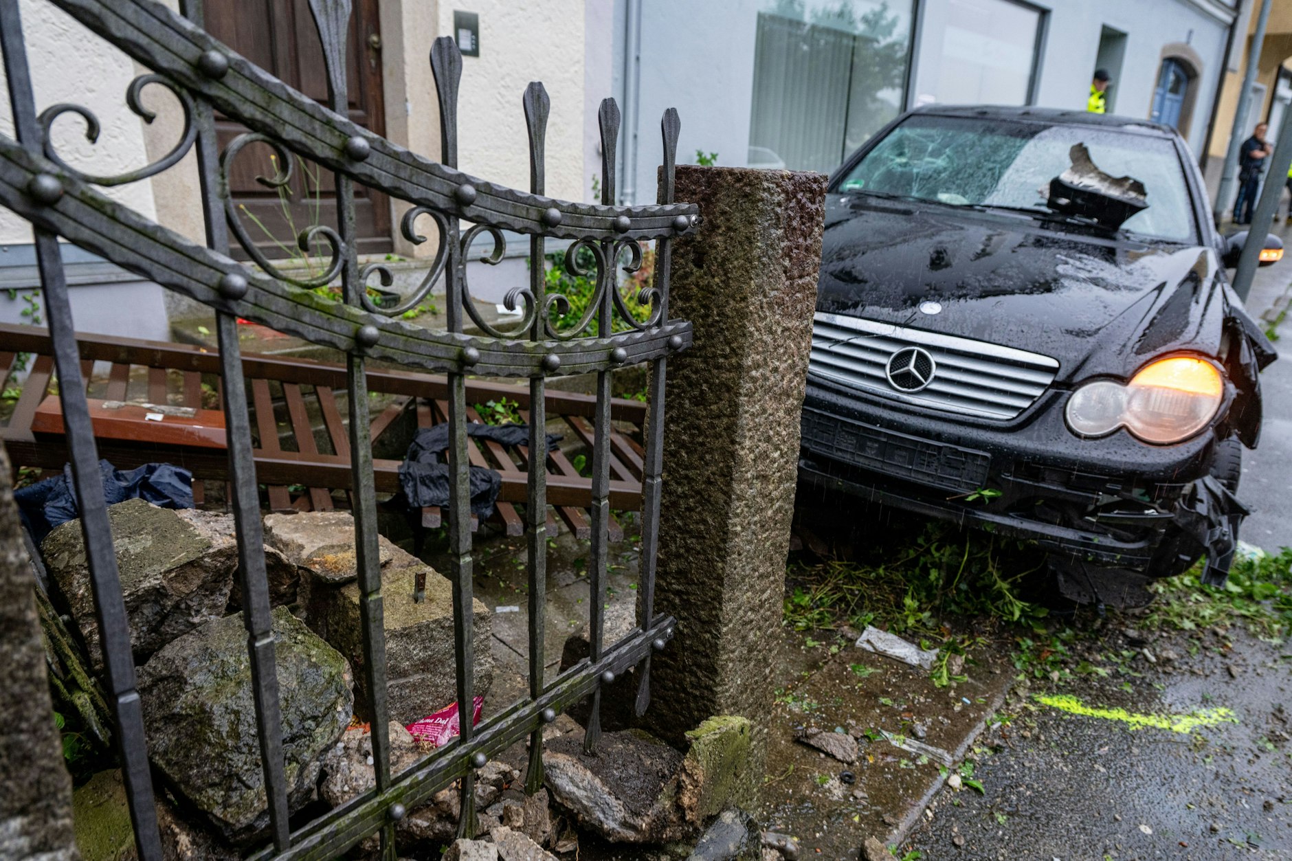 Ein beschädigtes Auto steht auf einem Gehweg. Ein Mann ist in Passau mit einem Wagen in eine Menschengruppe gefahren. Die Polizei vermutet eine Beziehungstat.