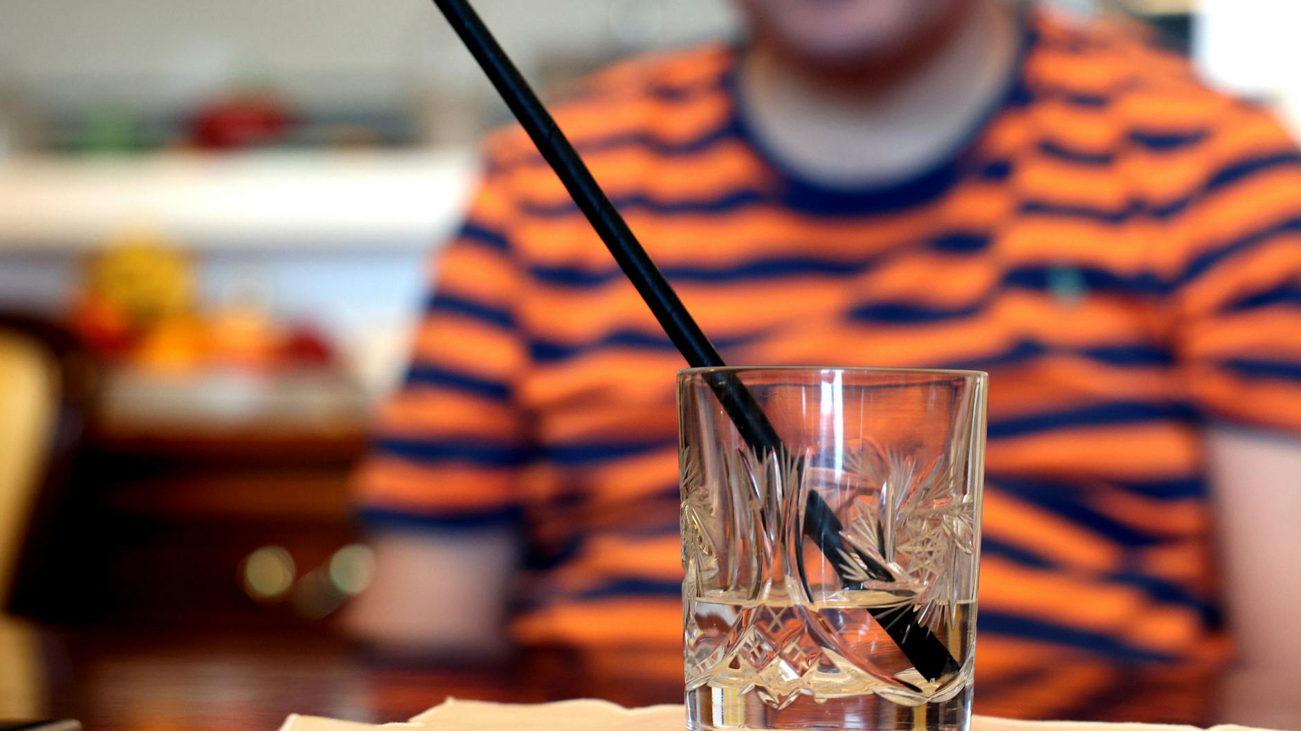 Der Berliner John (43) ist nach einem Impfschaden in seinem Leben sehr stark beeinträchtigt. Er kann wegen Muskelzitterns nur noch mit einem Halm trinken, das Getränk stellt ihm seine Mutter hin.