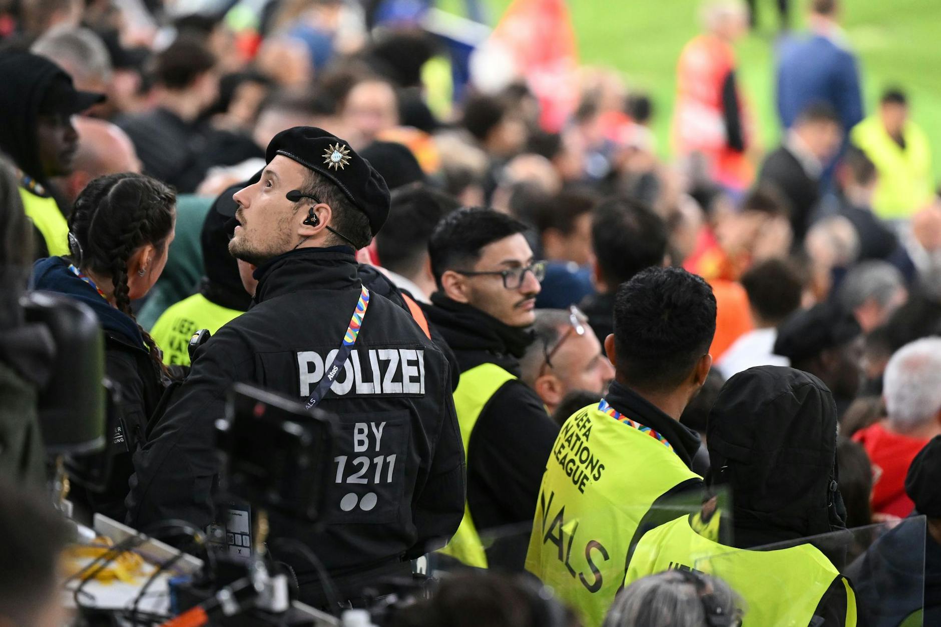 Ordner und ein Polizist stehen auf der Pressetribüne. Augenzeugen berichteten, dass eine Person vom zweiten Rang in den Bereich der Pressetribüne gefallen sein soll.