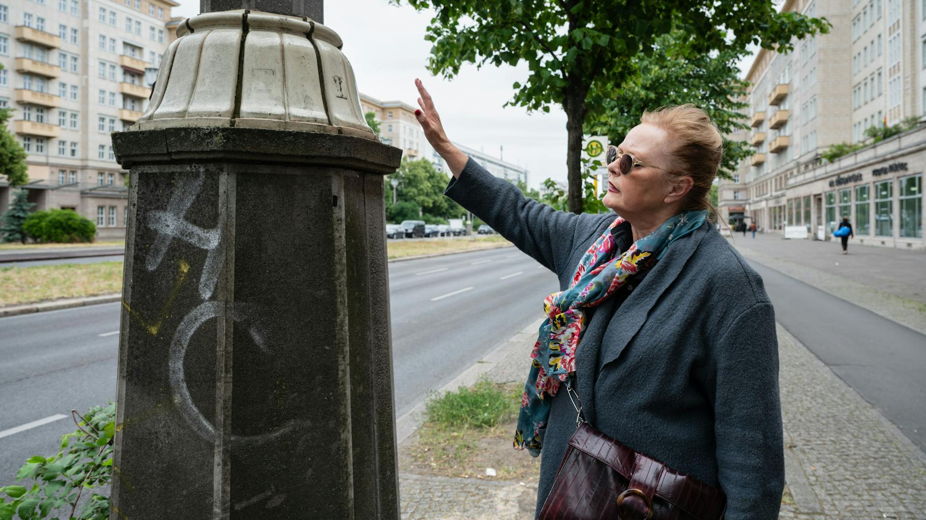 Sabine Heiser zeigt auf die denkmalgeschützten Kacheln der Straßenbeleuchtung. Zuschauer kletterten hier rauf, um besser zu sehen.
