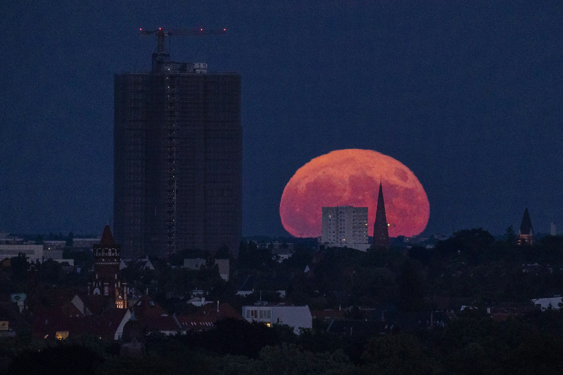 Der Erdbeermond im Juni 2022 über Berlin Steglitz. Am Horizont erscheint er besonders groß.