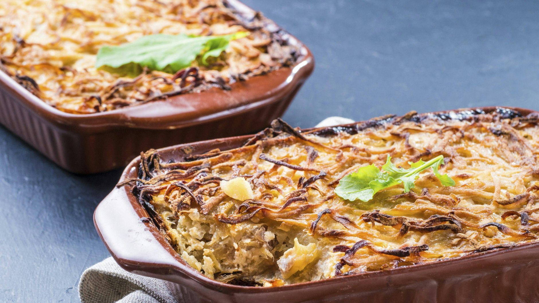Thüringer Käsepfanne ist ein ganz besonderer Kartoffelauflauf, bei dem die Kartoffeln gerieben und dann mit verschiedenen anderen Zutaten gebacken werden. Das Rezept kommt direkt aus dem bekanntesten Kochbuch der DDR.