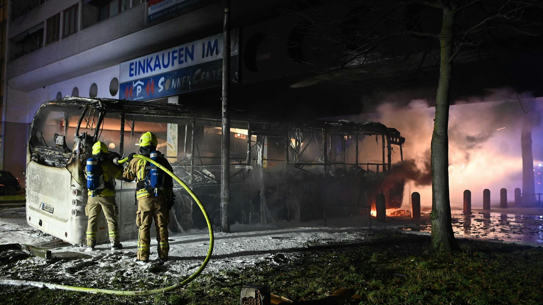 Die Bilder vom Jahreswechsel 2023 brannten sich ein. Hier löschen Feuerwehrleute einen brennenden Bus in der Sonnenallee in Neukölln.
